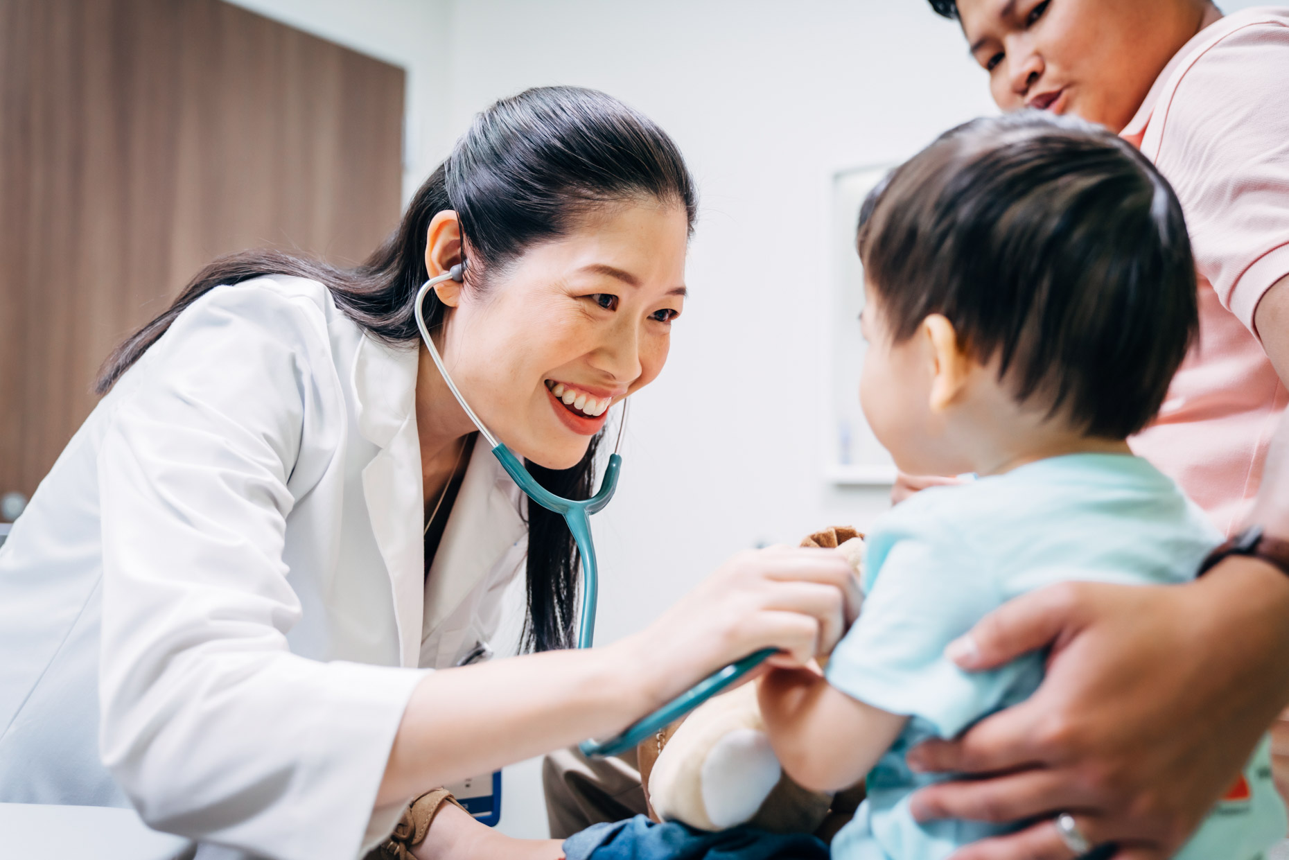 Asian female doctor checking toddler