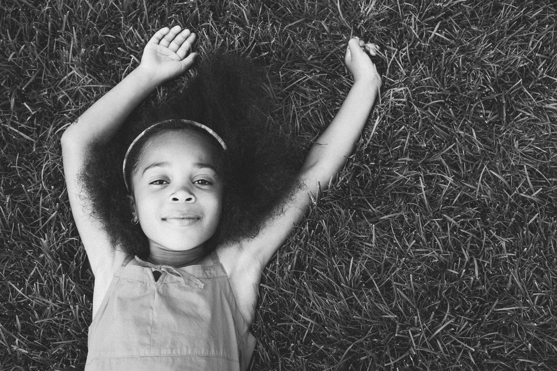 Black and white portrait of girl laying in grass