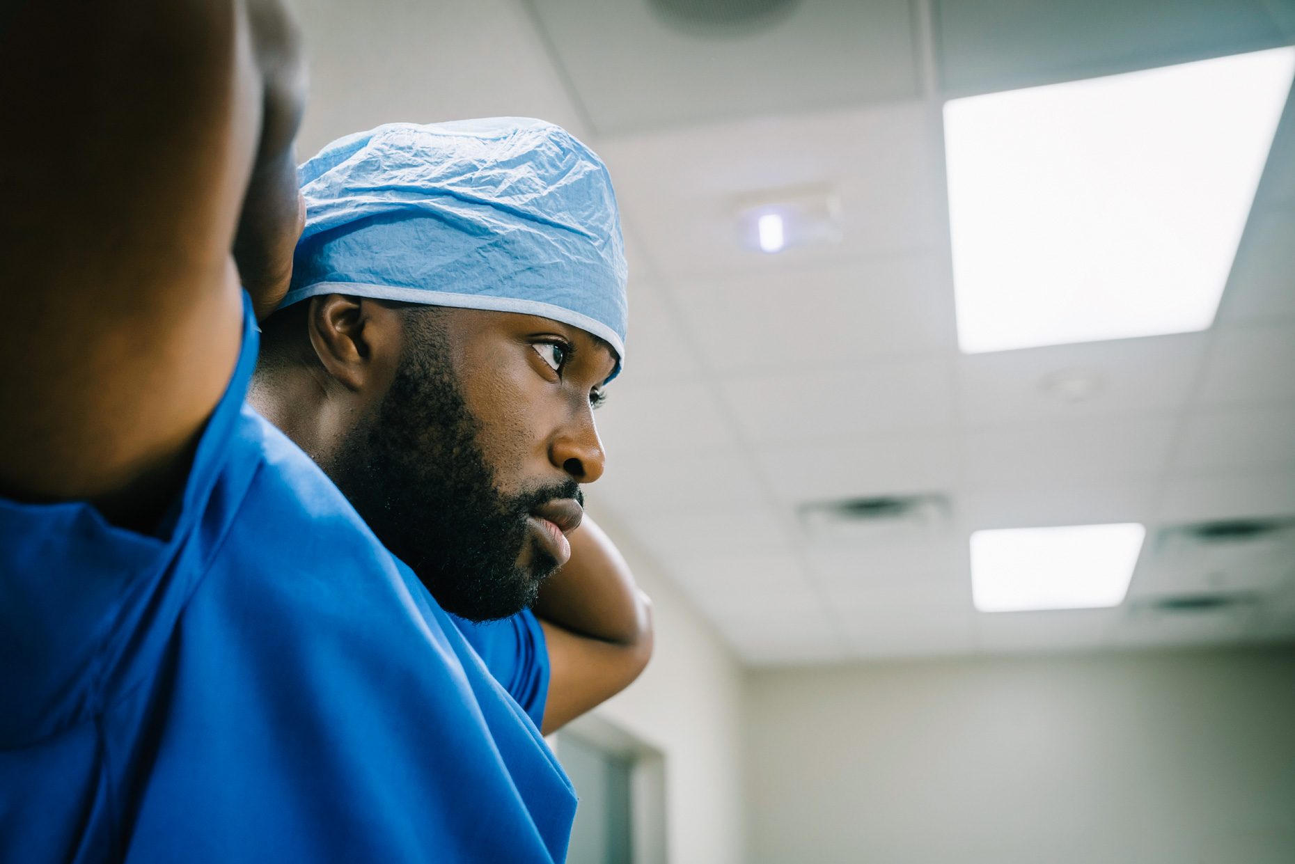 Black surgeon profile portrait with arms behind head