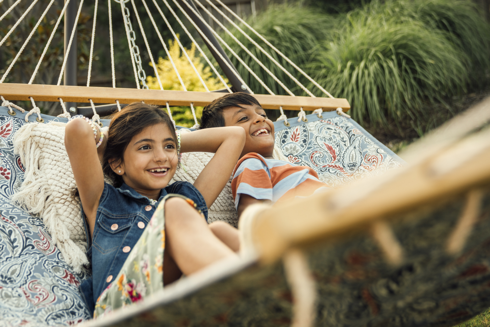 Boy-and-girl-laughing-together-in-hammock-20220608_Elyson_Scene4B_ModelHome_0122