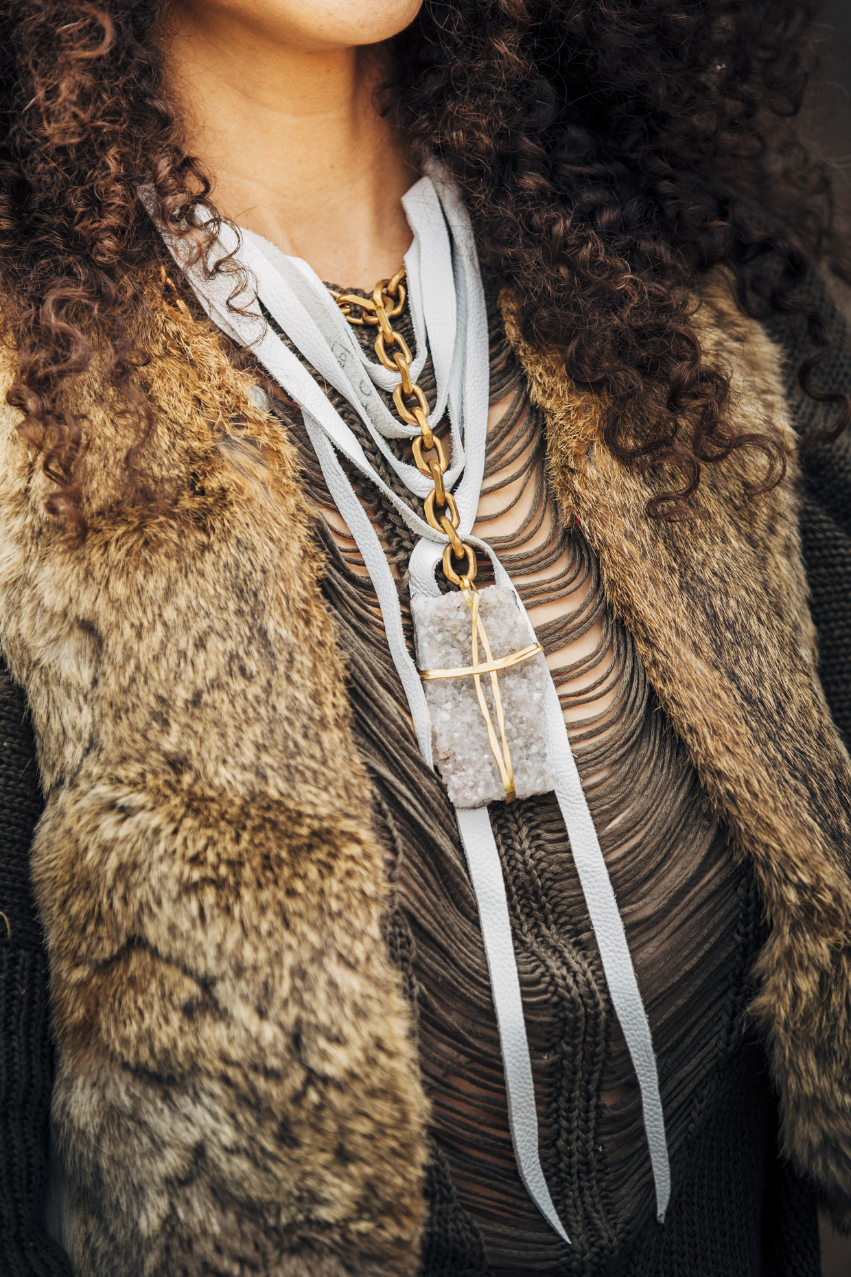 Close up of woman in fur vest wearing Belthazzar stone and leather necklace