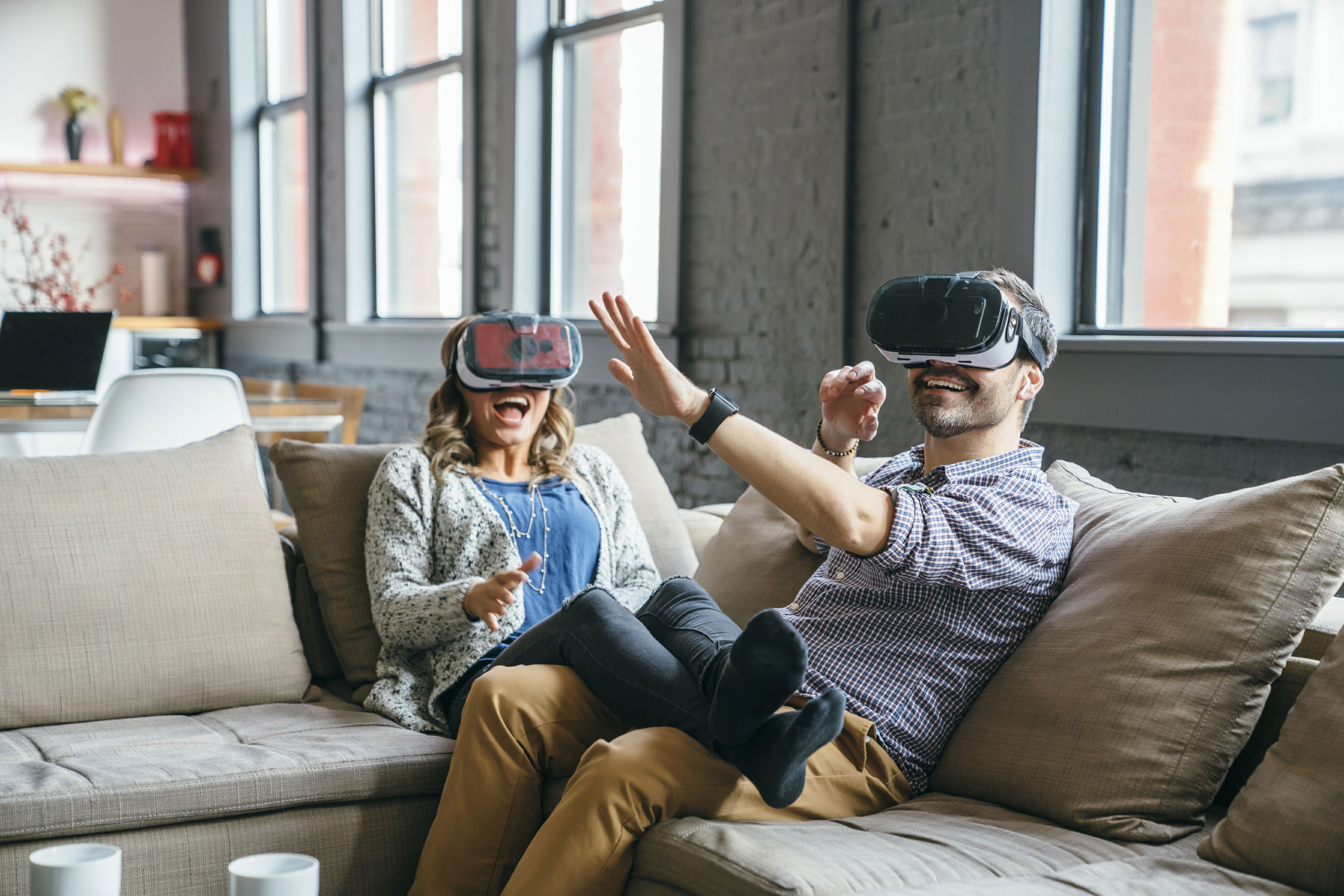 Couple-virtual-reality-glasses-on-couch-laughing-Inti-St-Clair-LYDA_201612133331