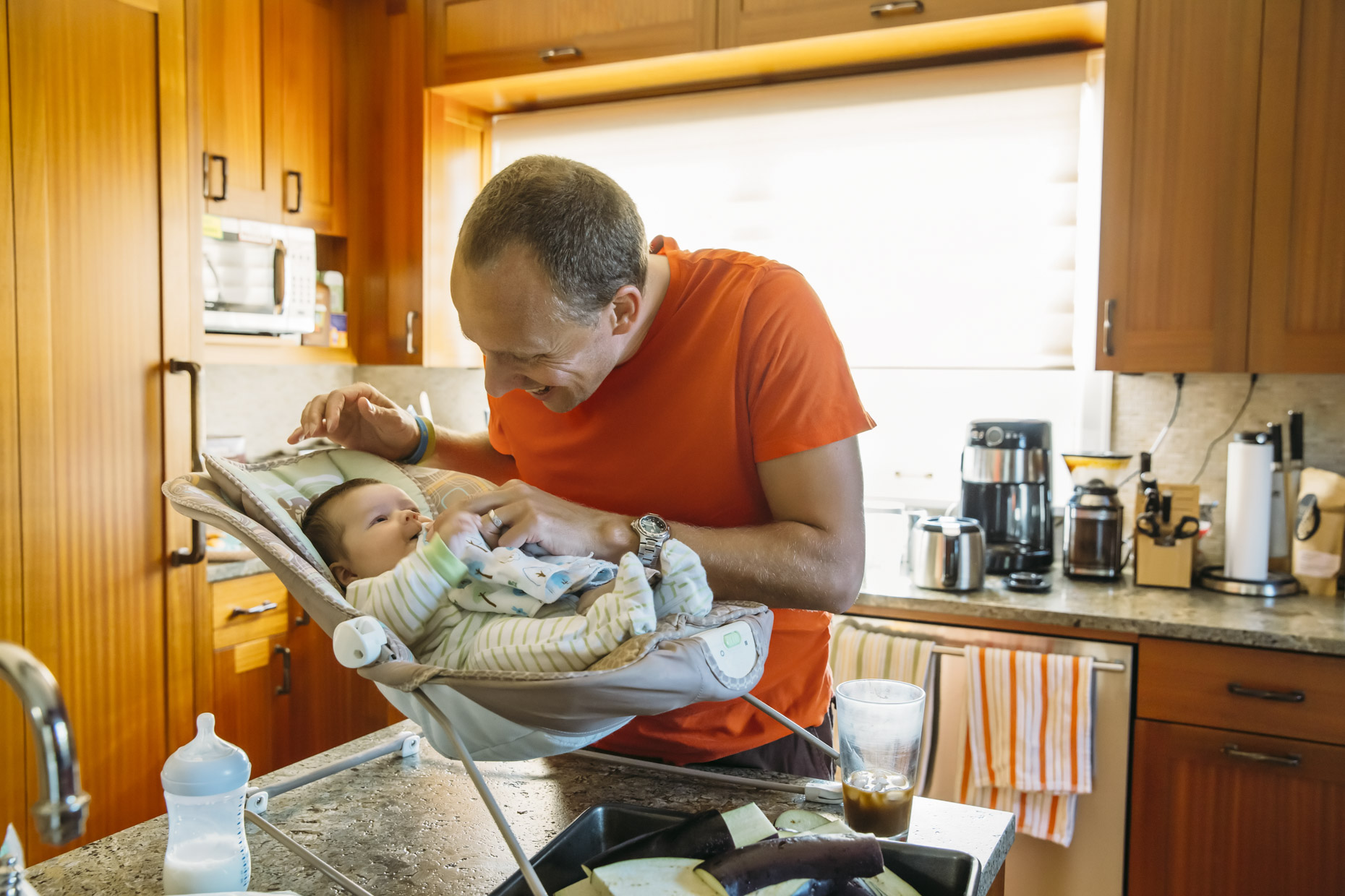 Dad playing with baby in kitchen