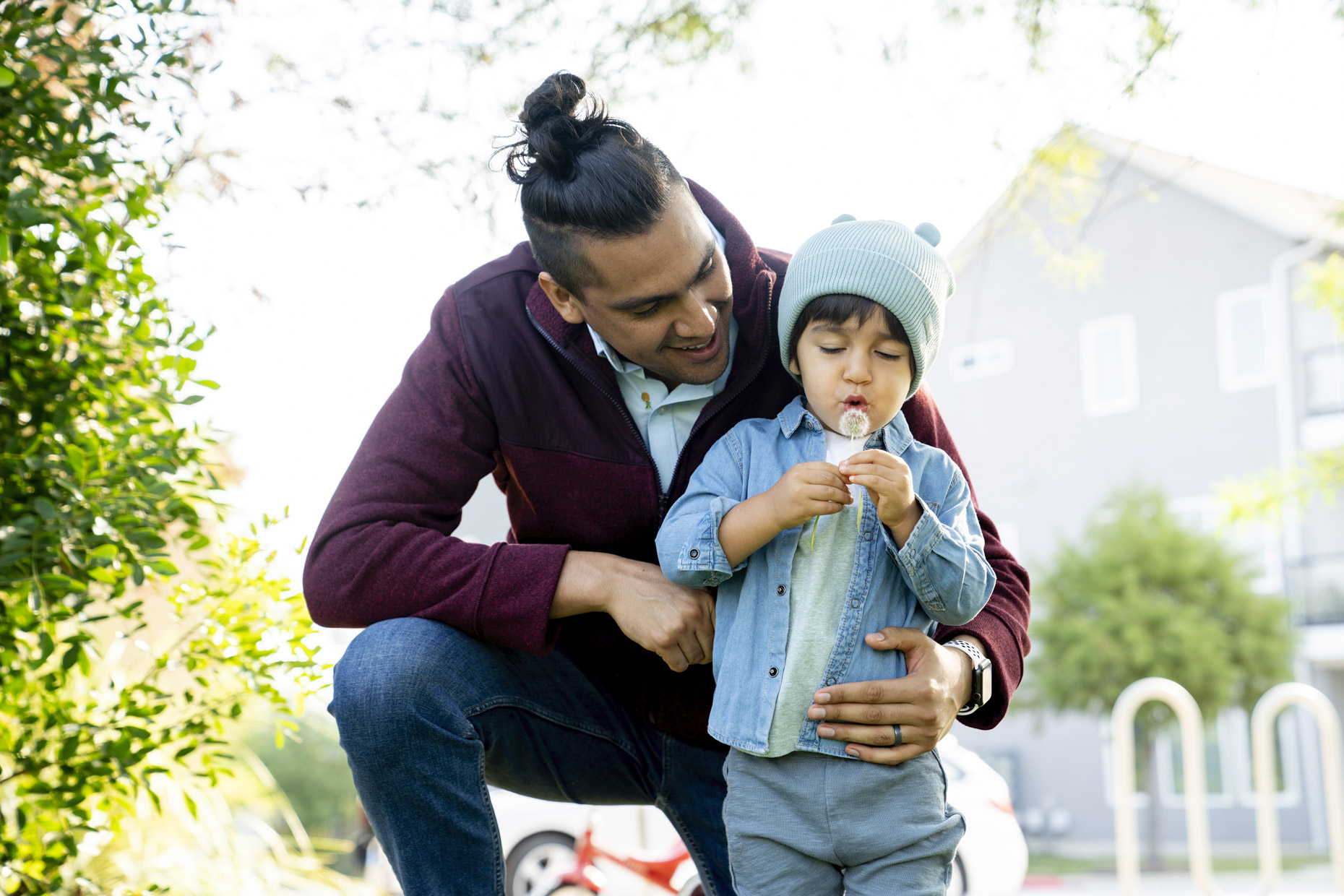 Dad showing son how to blow dandilion