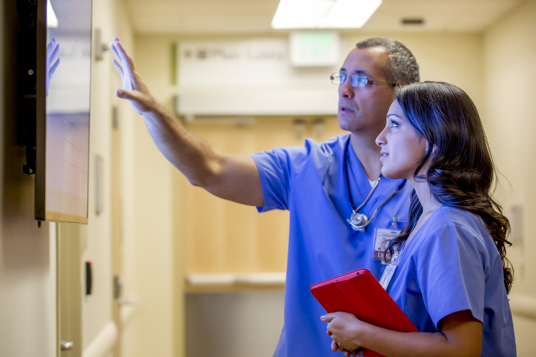 Doctor and nurse discussing patient care information on monitor in hospital