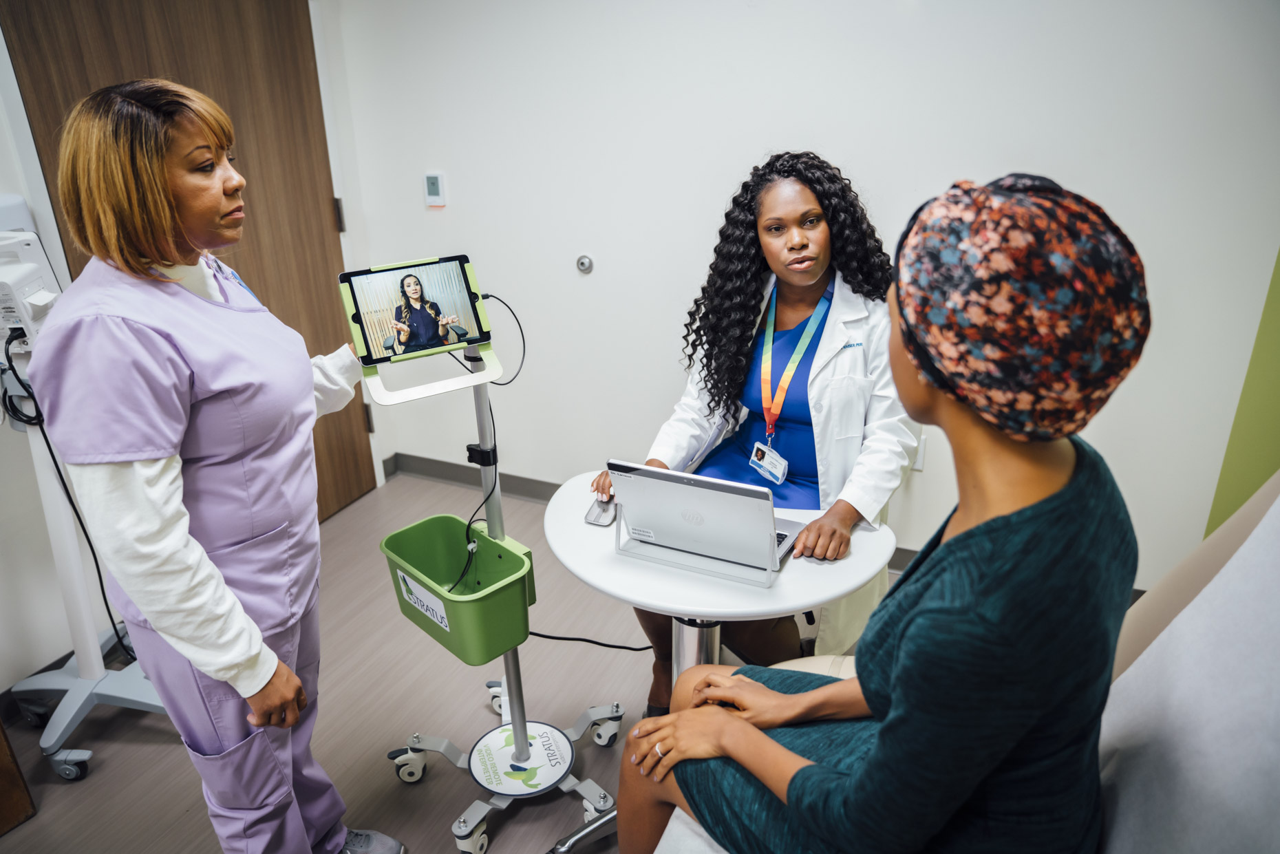 Doctor and nurse talking with patient using remote translator