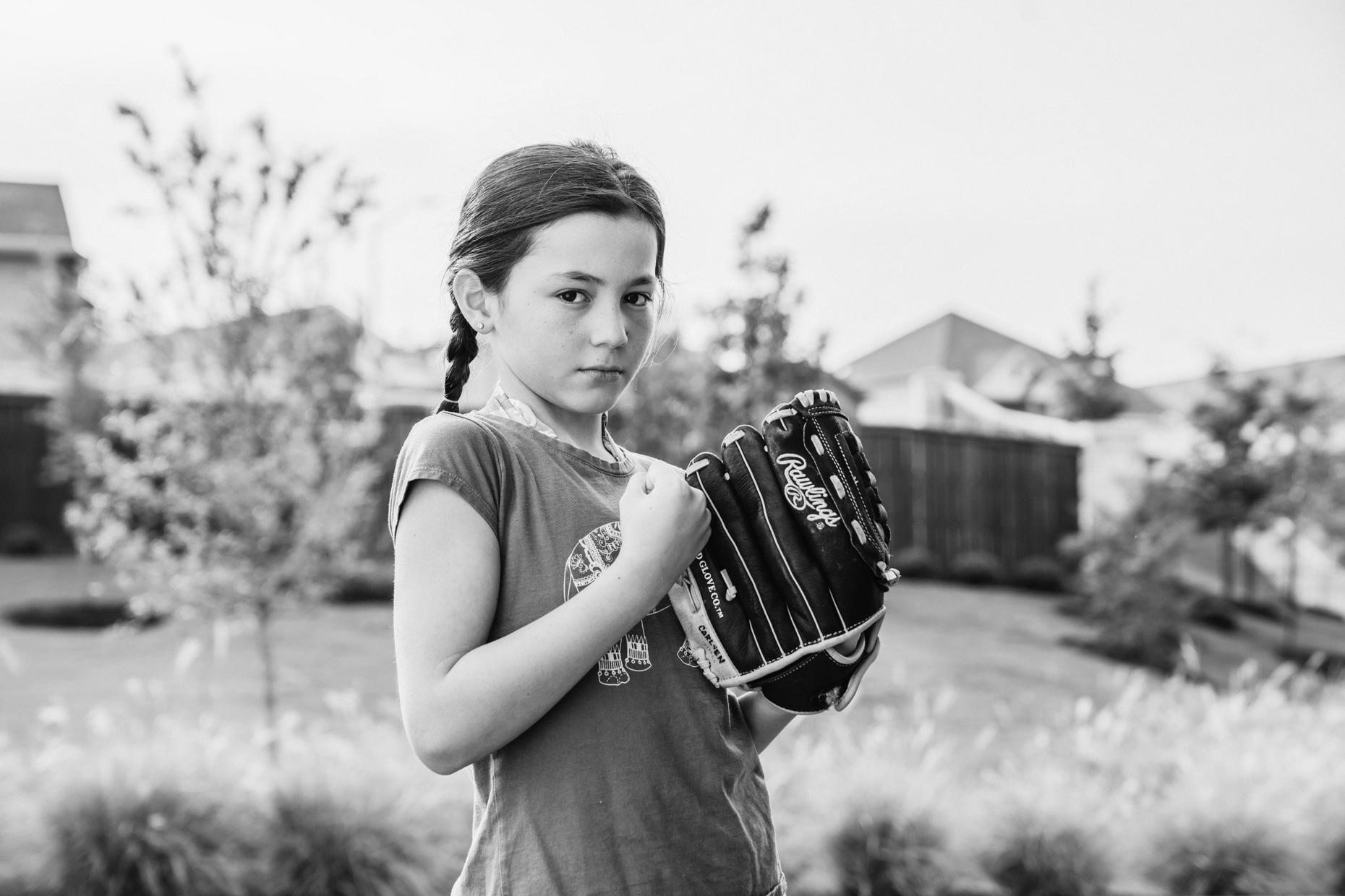 GIrl holding up fist with baseball glove 