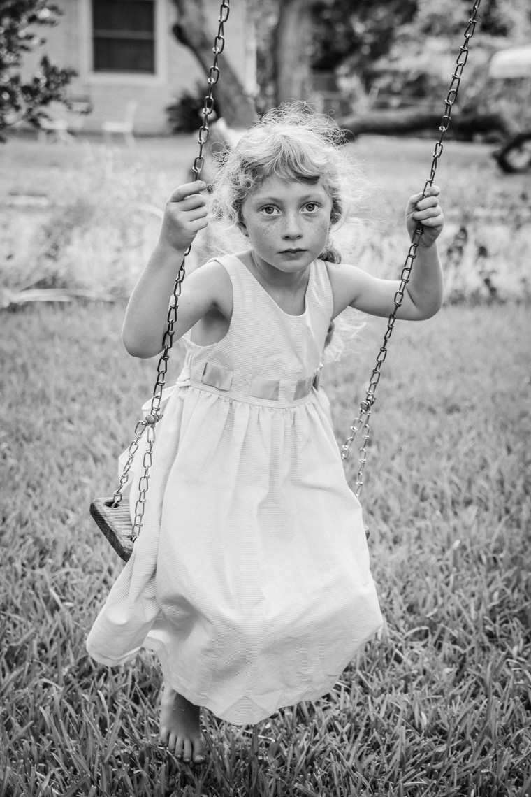 Girl in dress on swing in yard