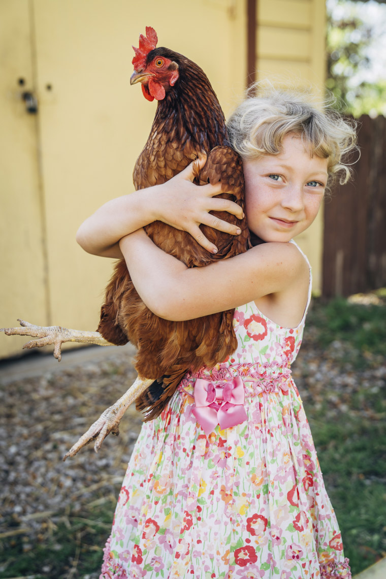 Girl in summer dress holding chicken