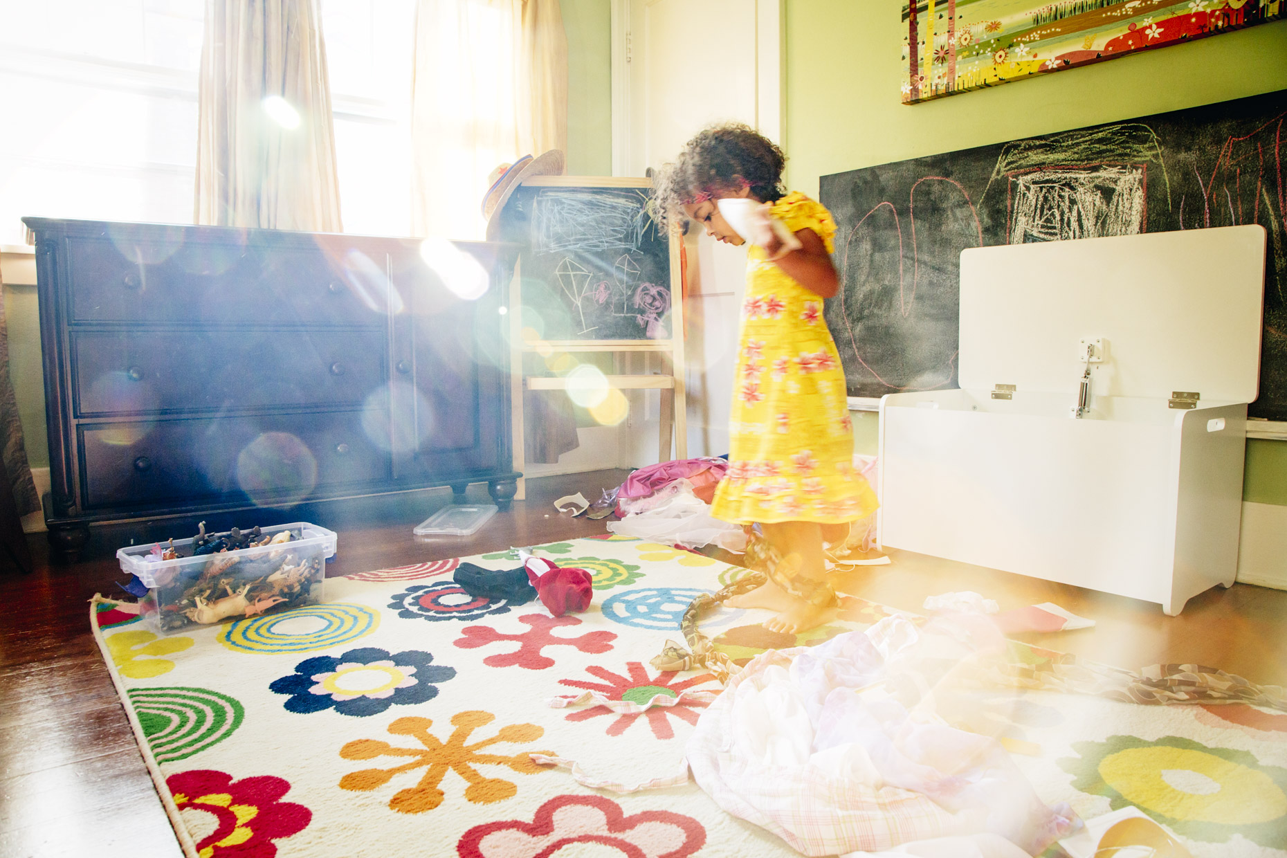 Girl playing dress-up in sunlight filled bedroom