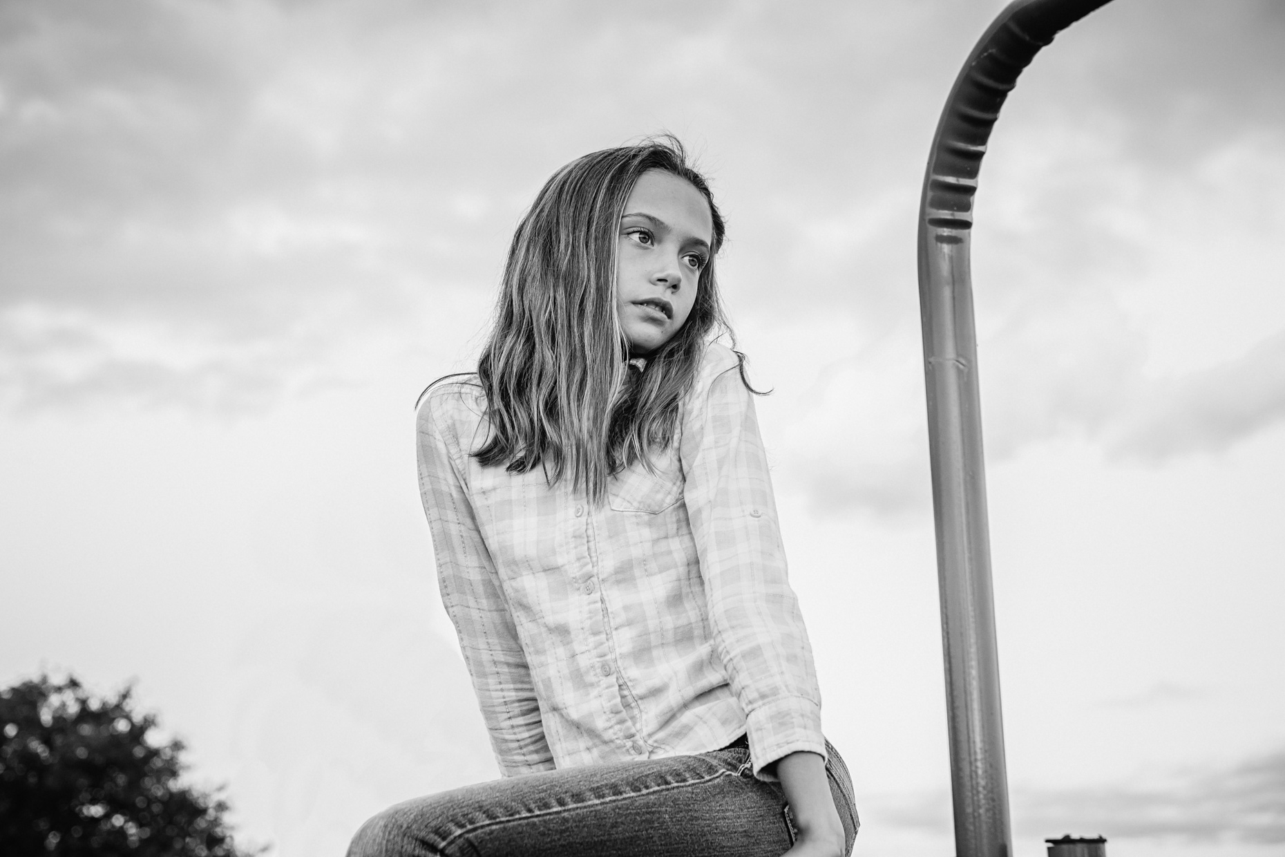 Girl sitting on fence in black and white