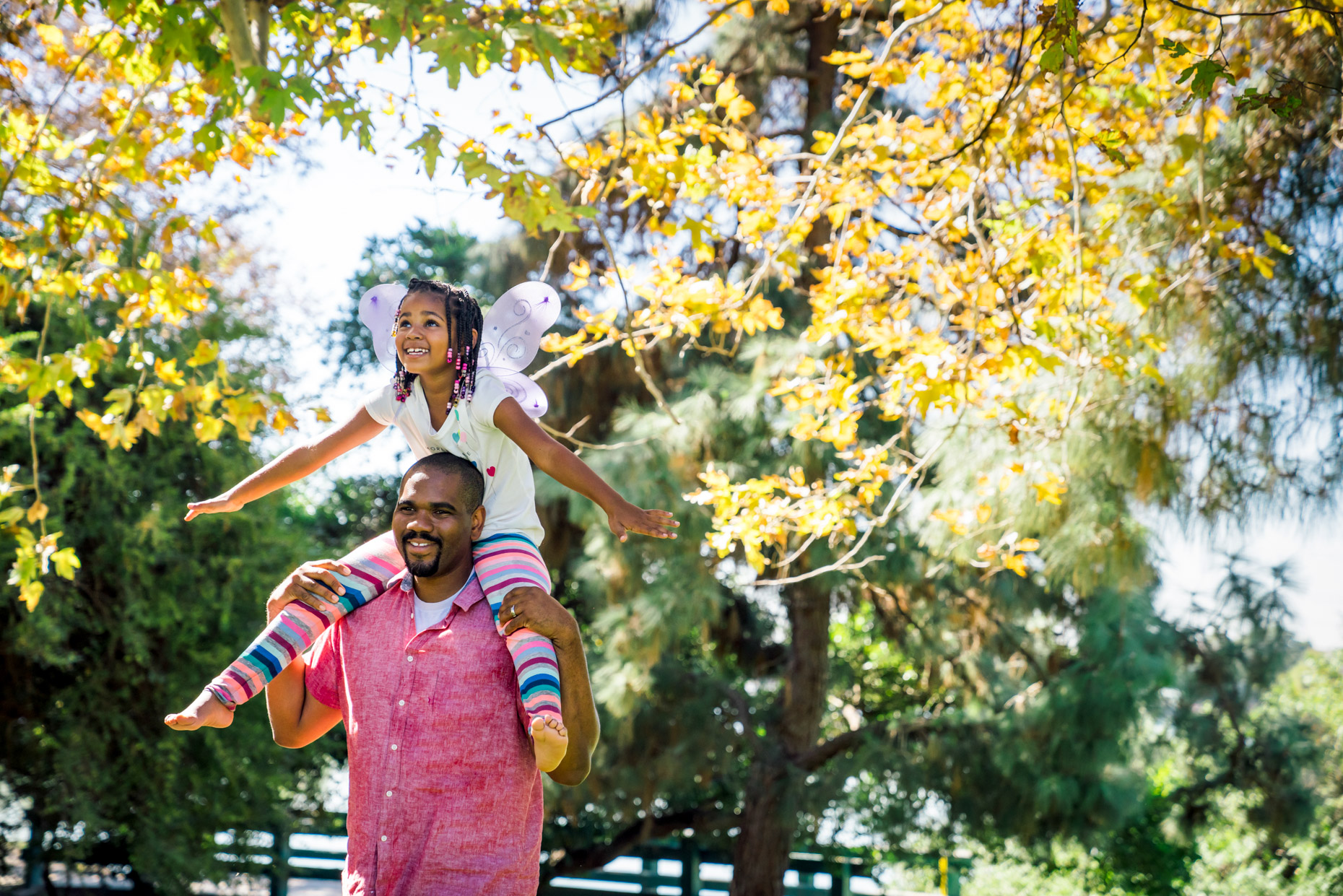 Girl with wings on riding on dad