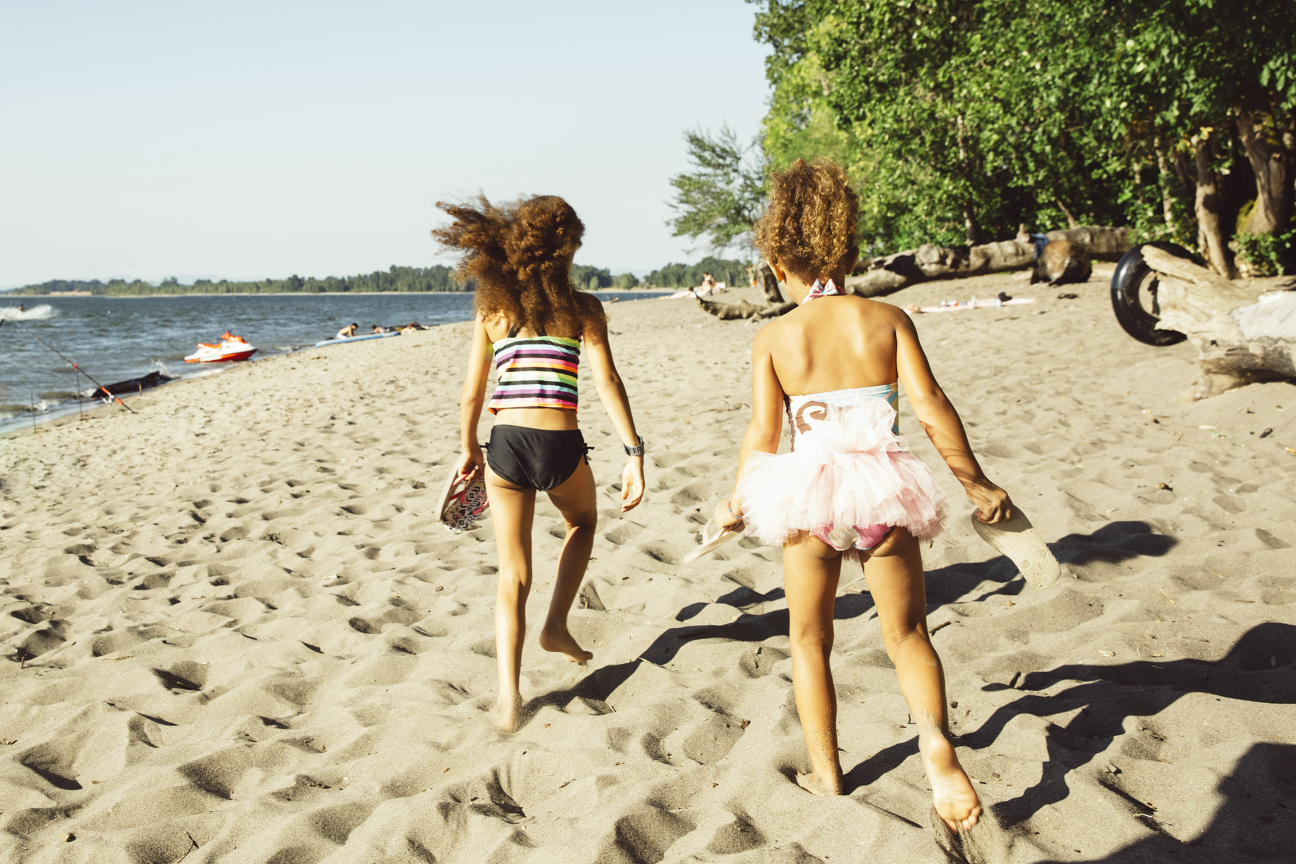 Girls in swimsuits and tutu running on beach