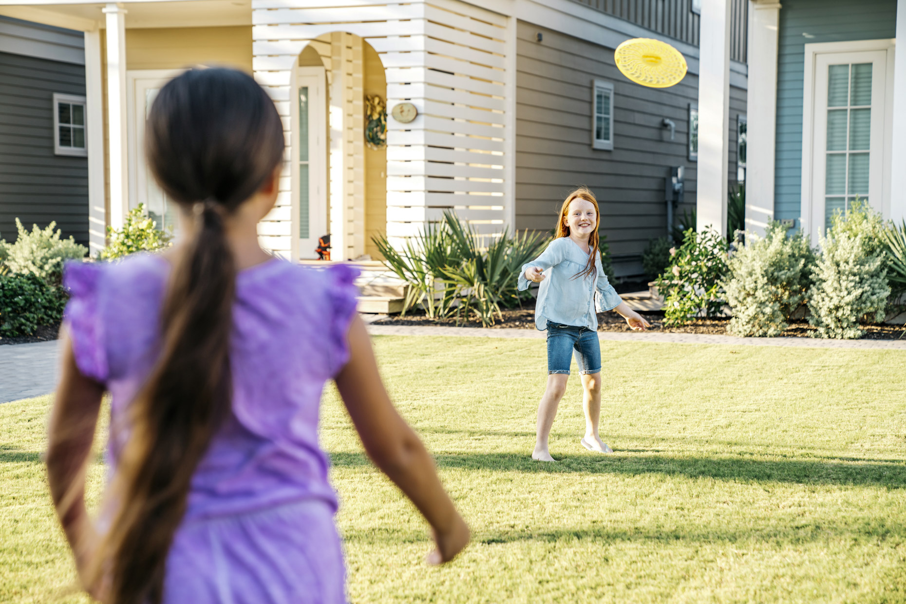 Girls playing with frisbee in yard