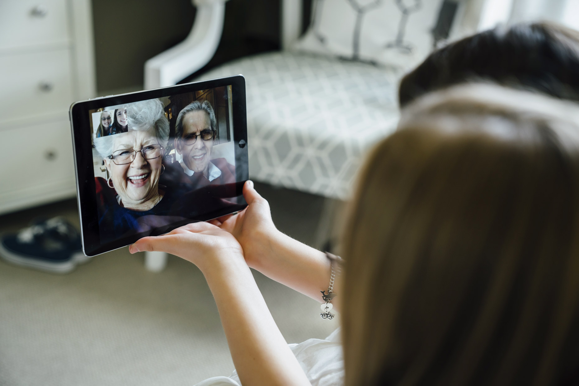 Grandparents video chatting on iPad tablet computer with grand children