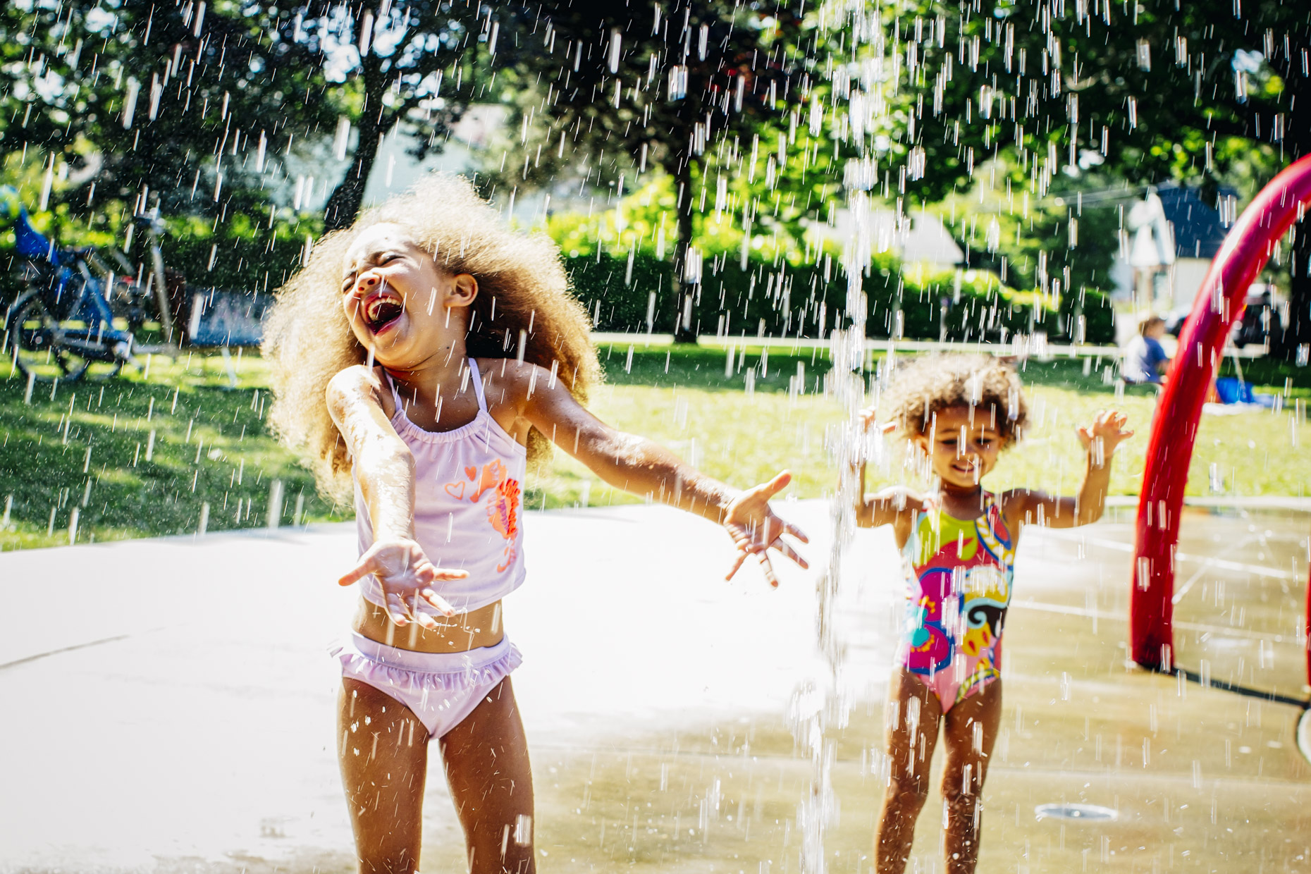 Mixed race girls with afros playing in water park