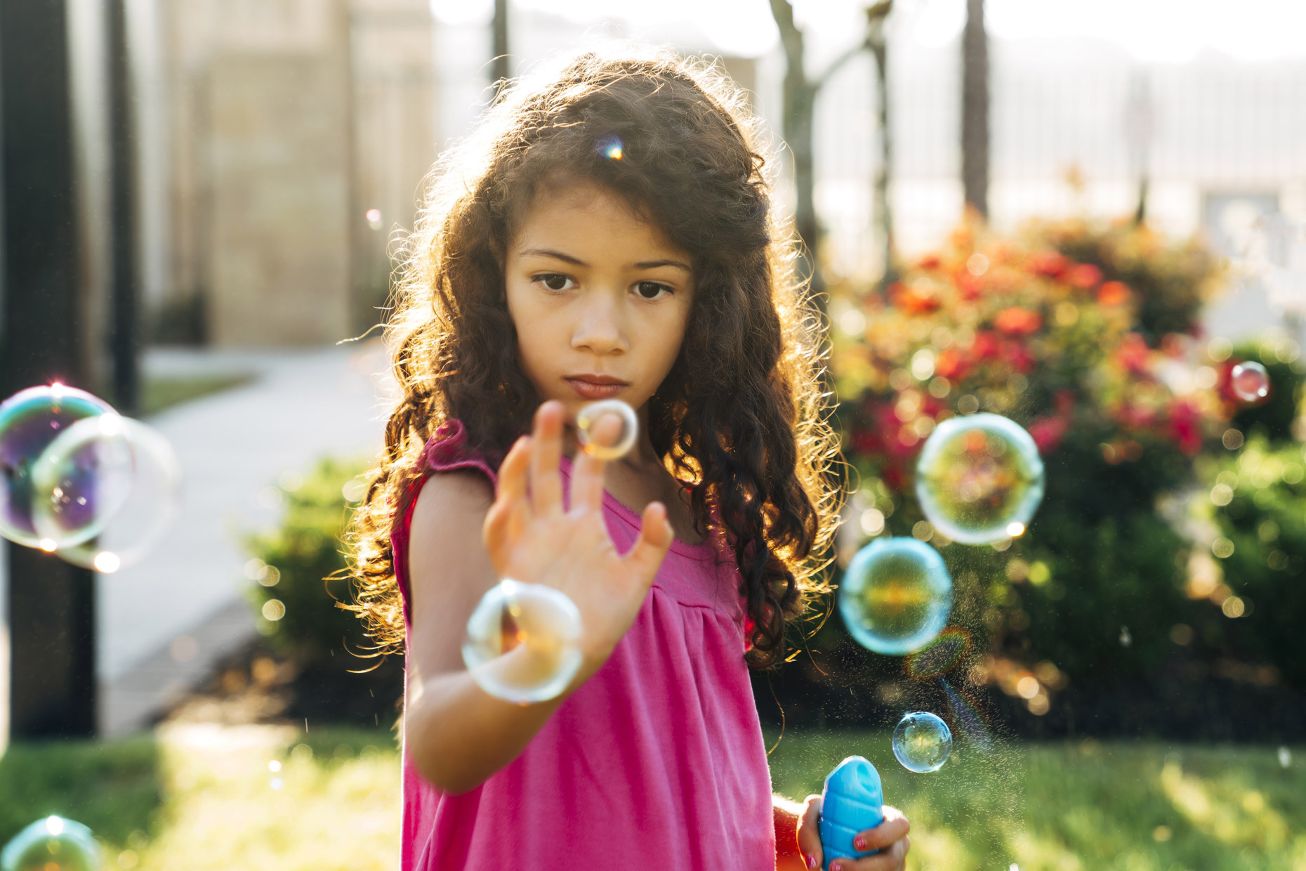 Hispanic girl popping bubbles outside in park