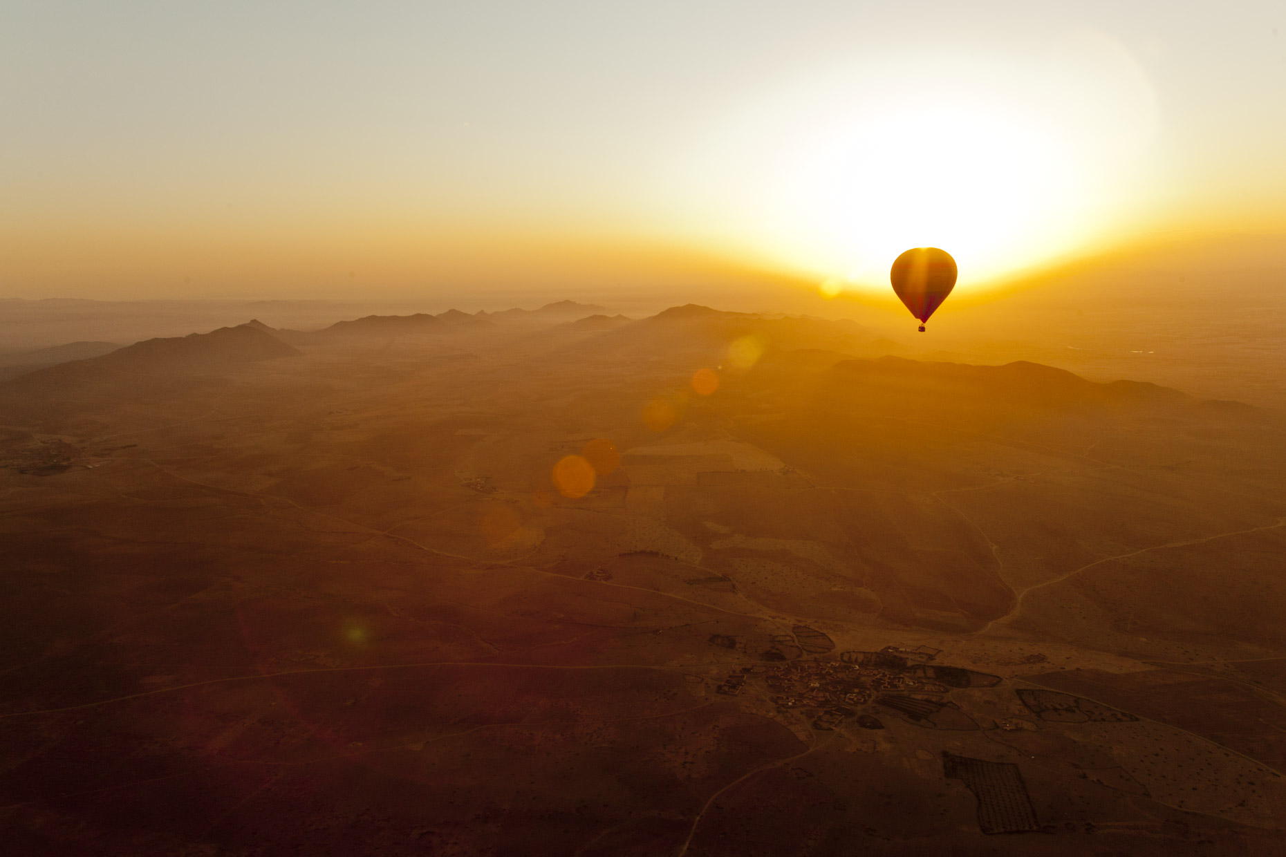 Hot air baloon at sunrise over the Moroccan desert