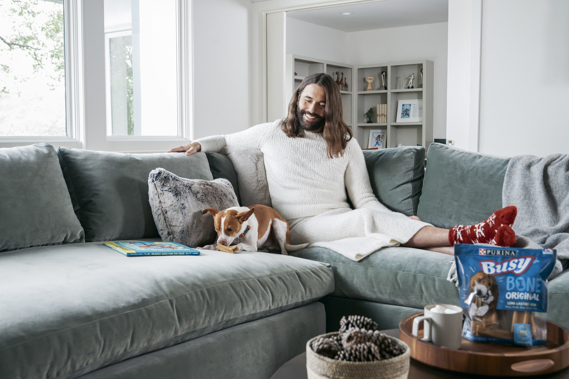Jonathan Van Ness watching pet dog Pablo on couch with Purina Busy Bone treat 