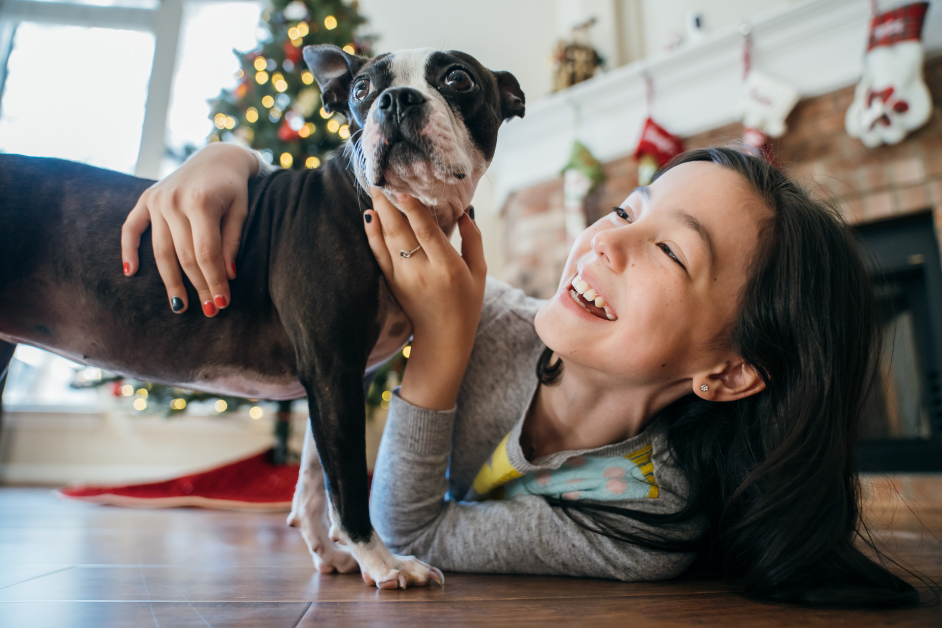 Little-girl-smiling-looking-at-dog-on-floor-at-chirstmas-20201220_Degner_0781