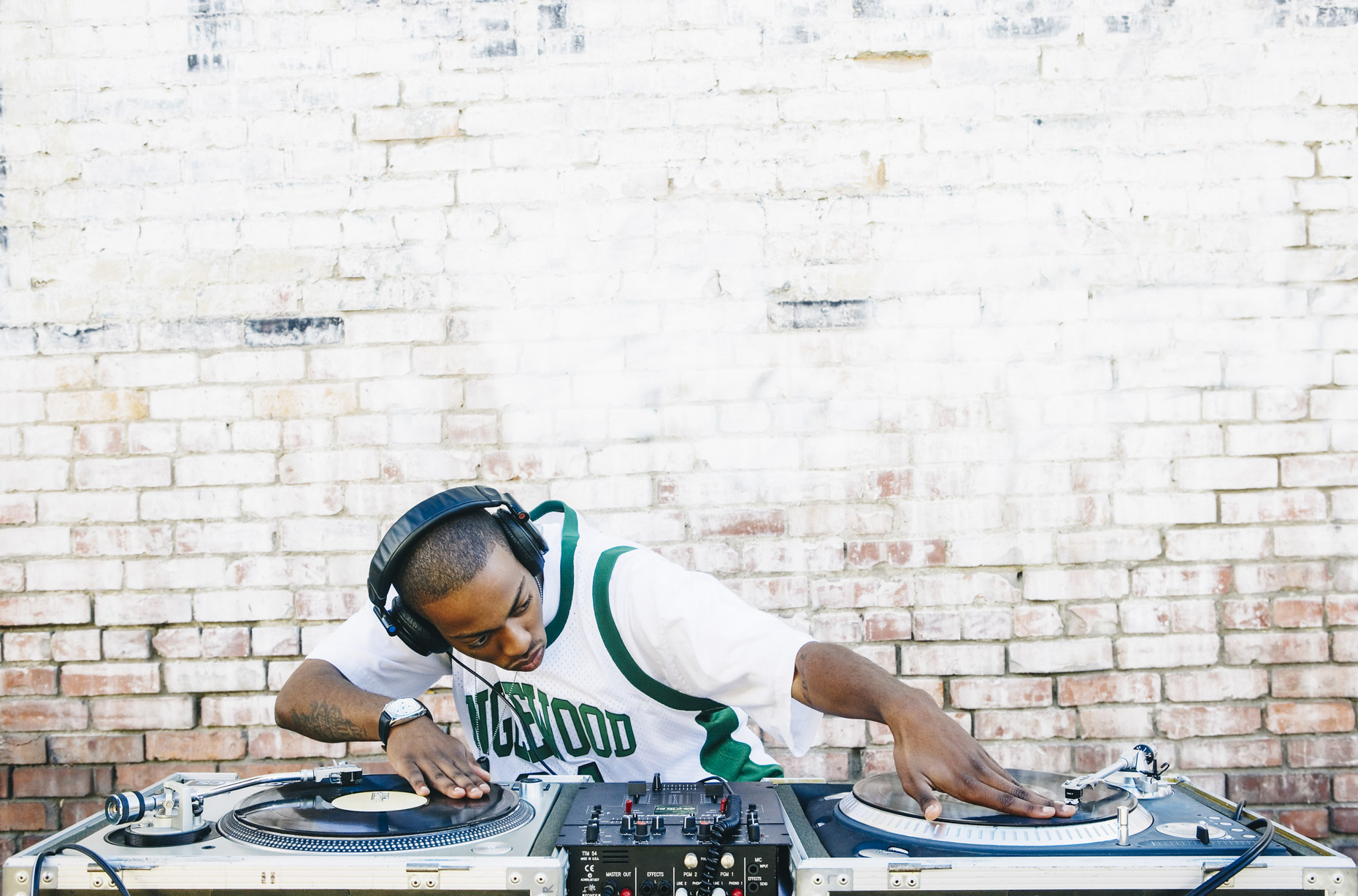 Male DJ in sports jersey mixing records on turn table