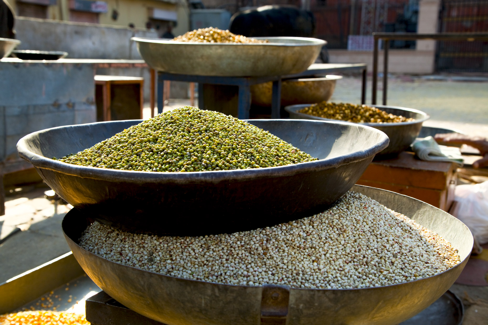 Metal bowls full of lentils in outdoor market in India