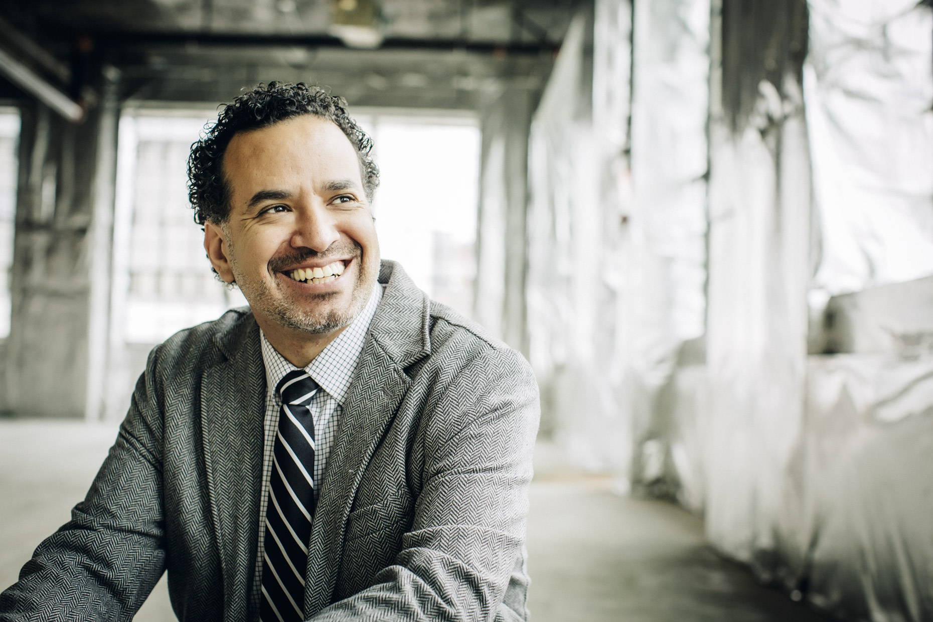 Smiling mixd race man in business suit on construction site 