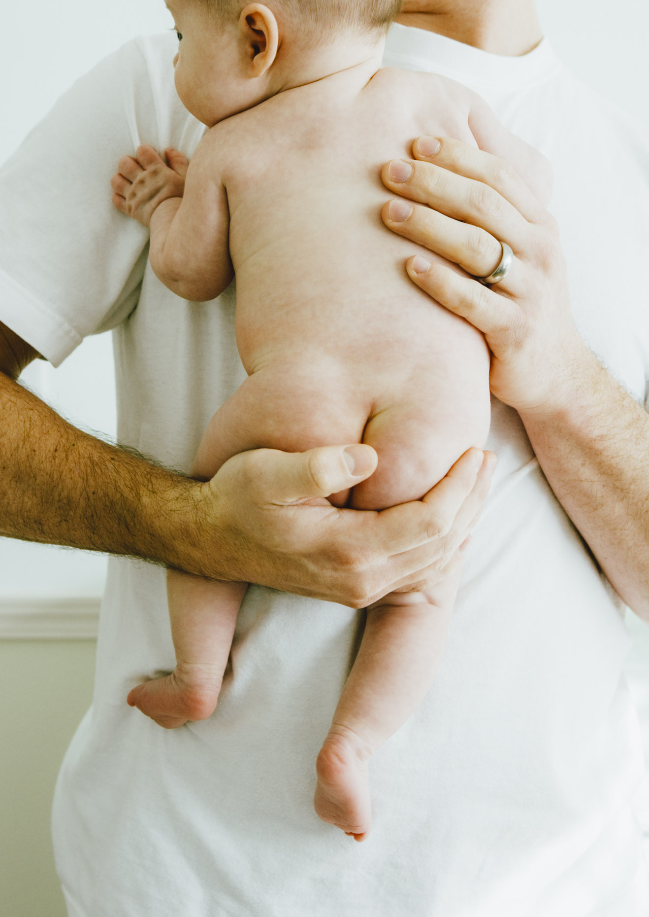 Naked baby held in dad
