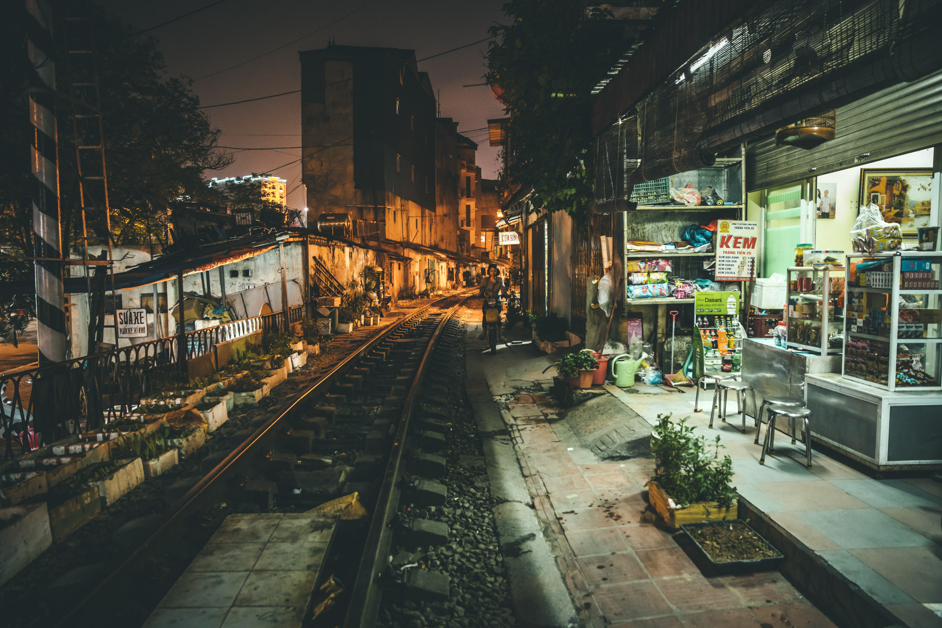 Nightscape of railroad tracks next to grocery store in Hanoi, Vietnam