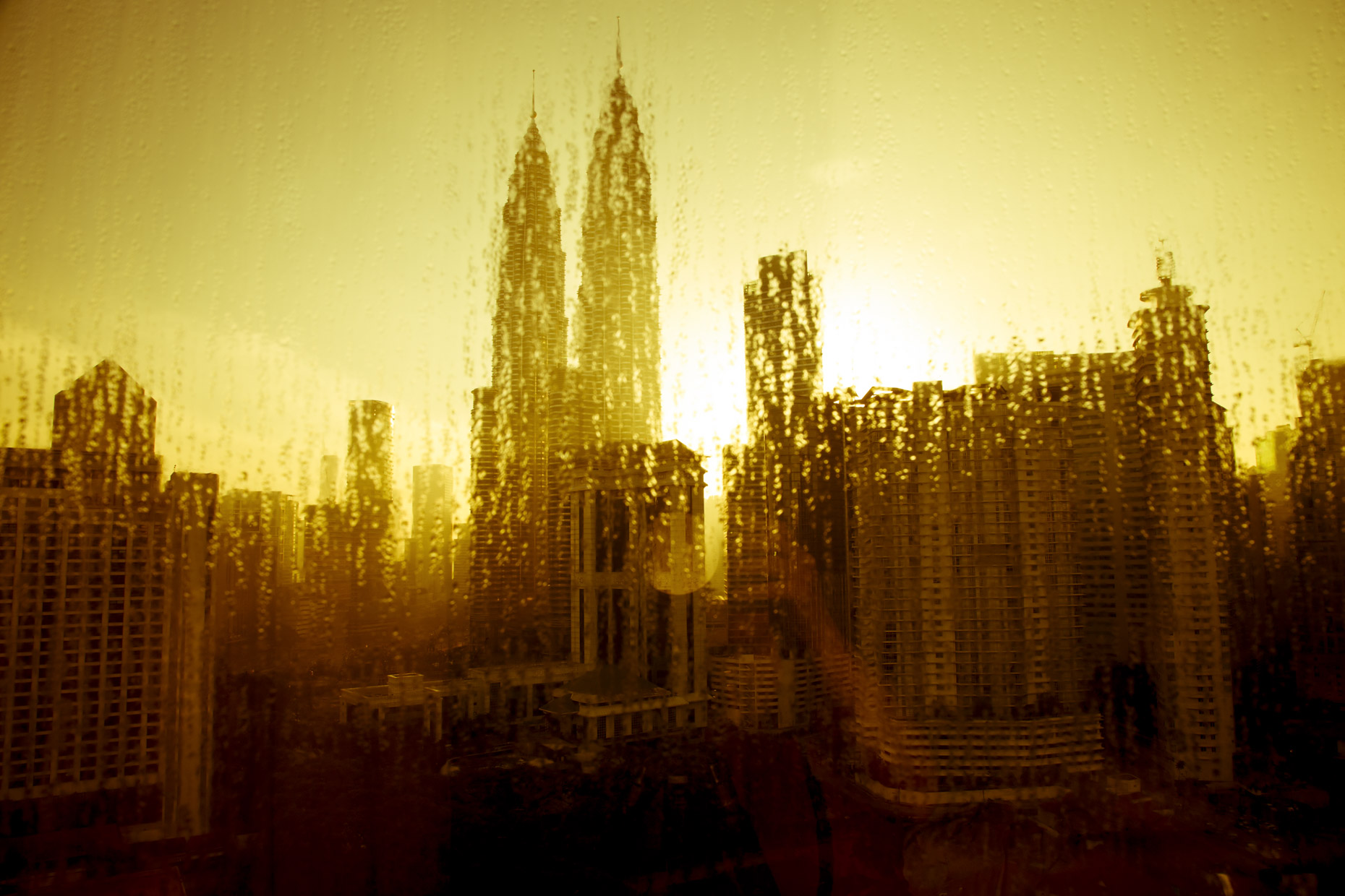Patronas Towers in Kuala Lumpur Malysia at sunrise through rain covered window