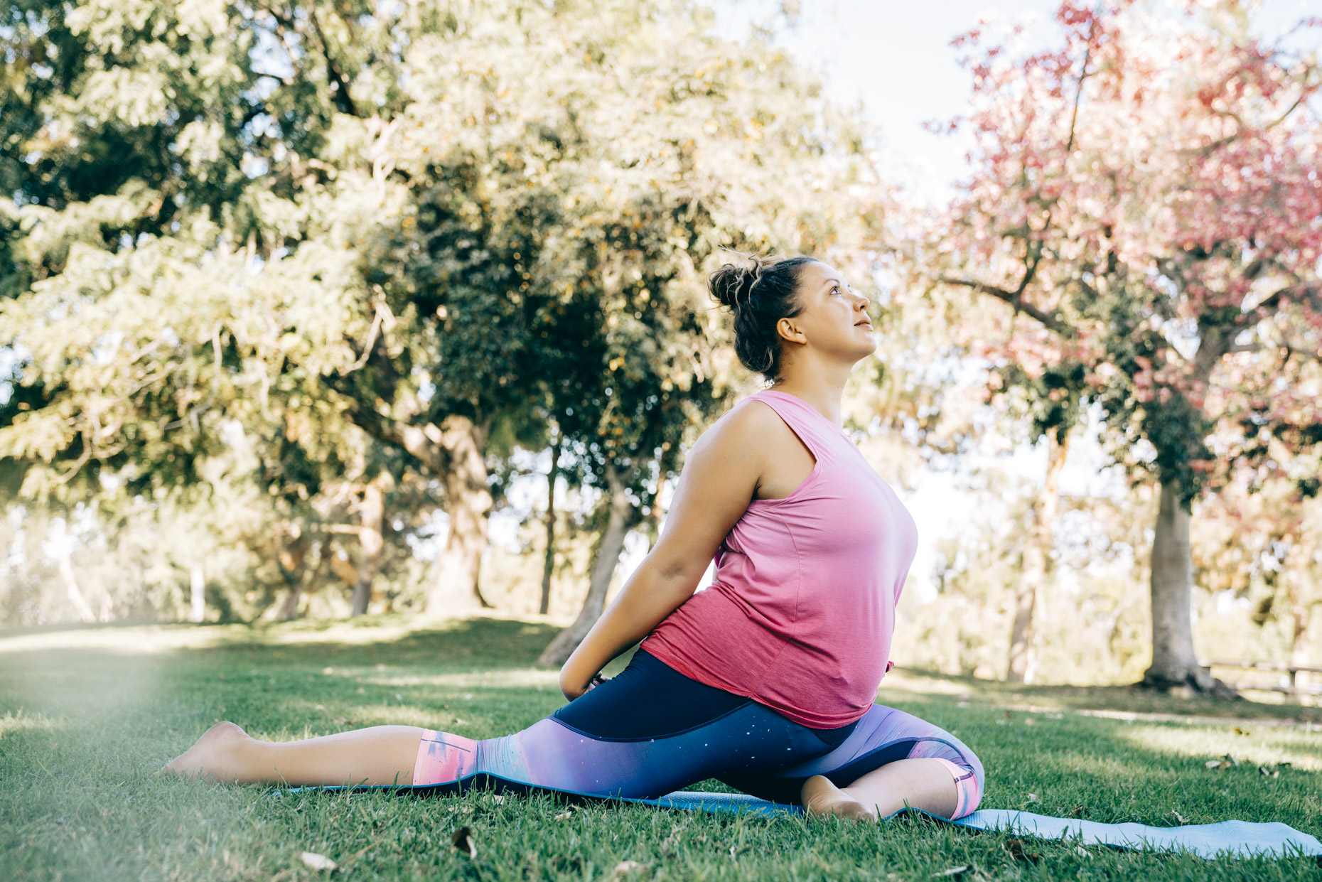 Plus-sized woman doing yoga outside in park