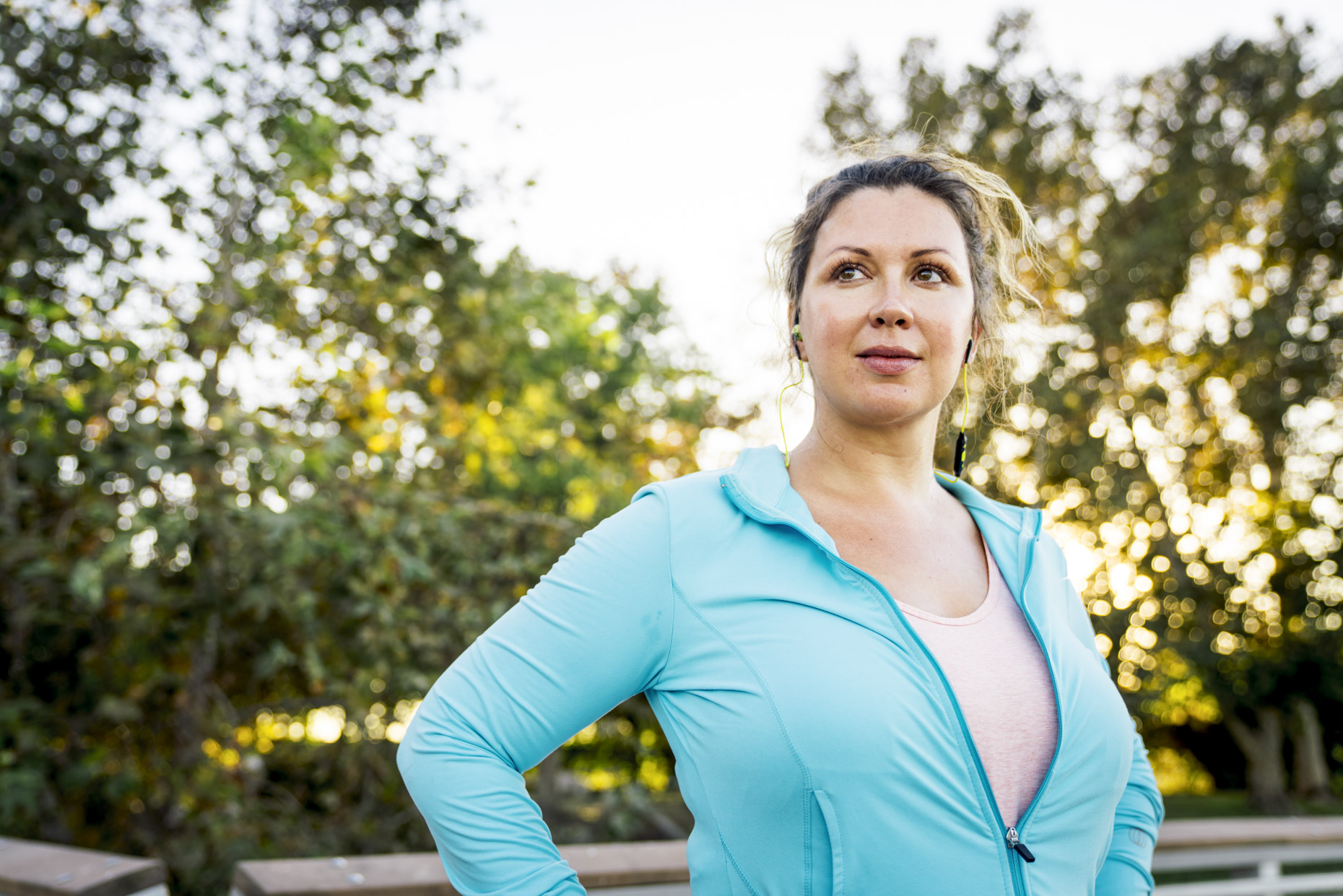 Plus-sized woman in fitness attire looking off in to distance