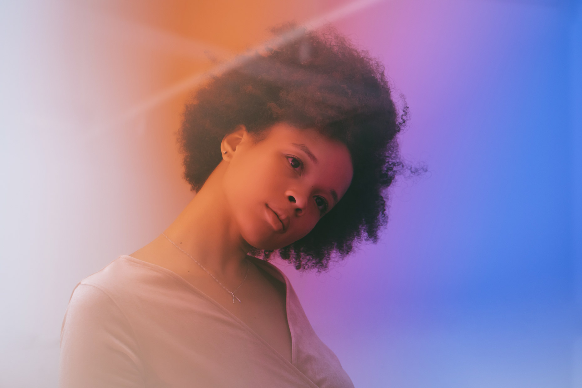 Portrait of woman with afro in rainbow light