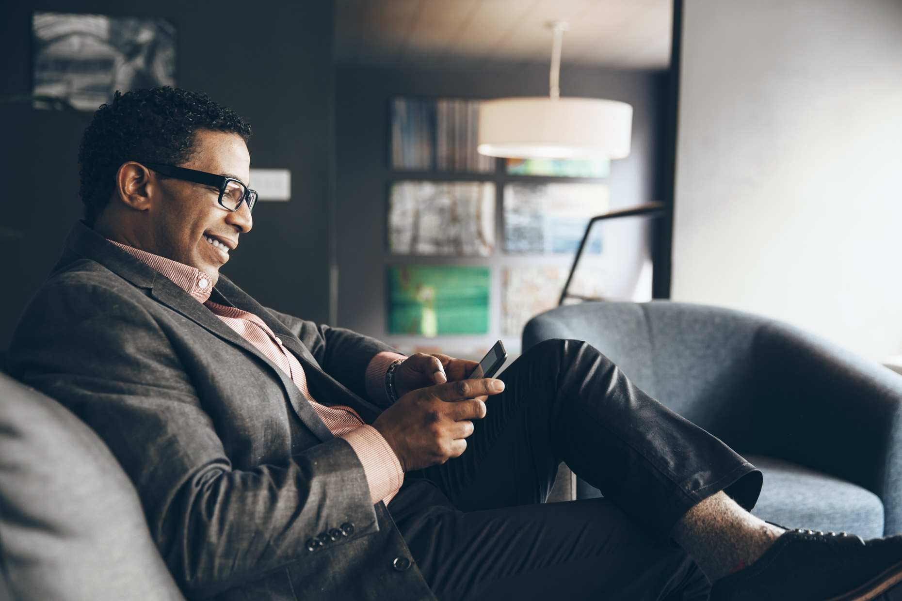 Portrait of smiling business man sitting and texting on phone
