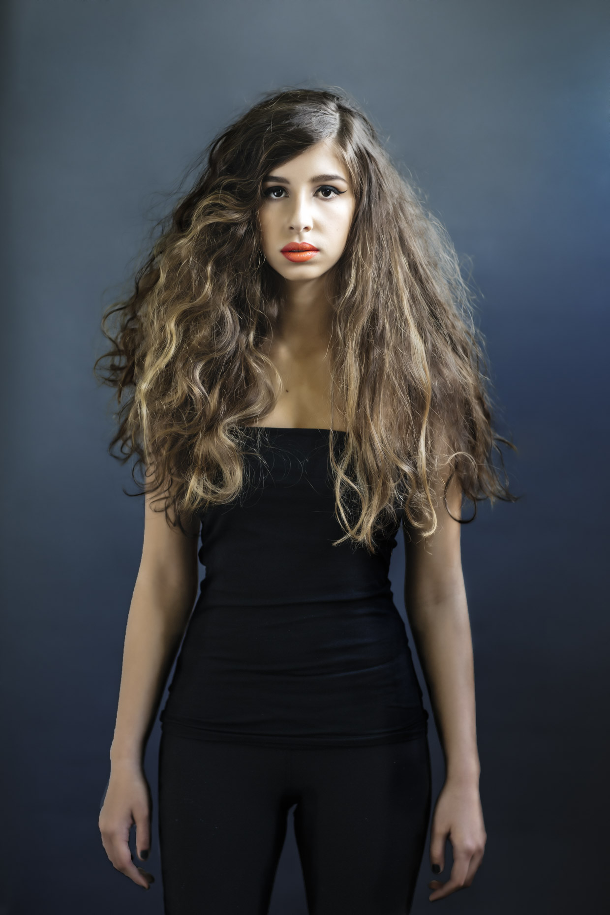 Portrait of woman with big long hair dressed in all black