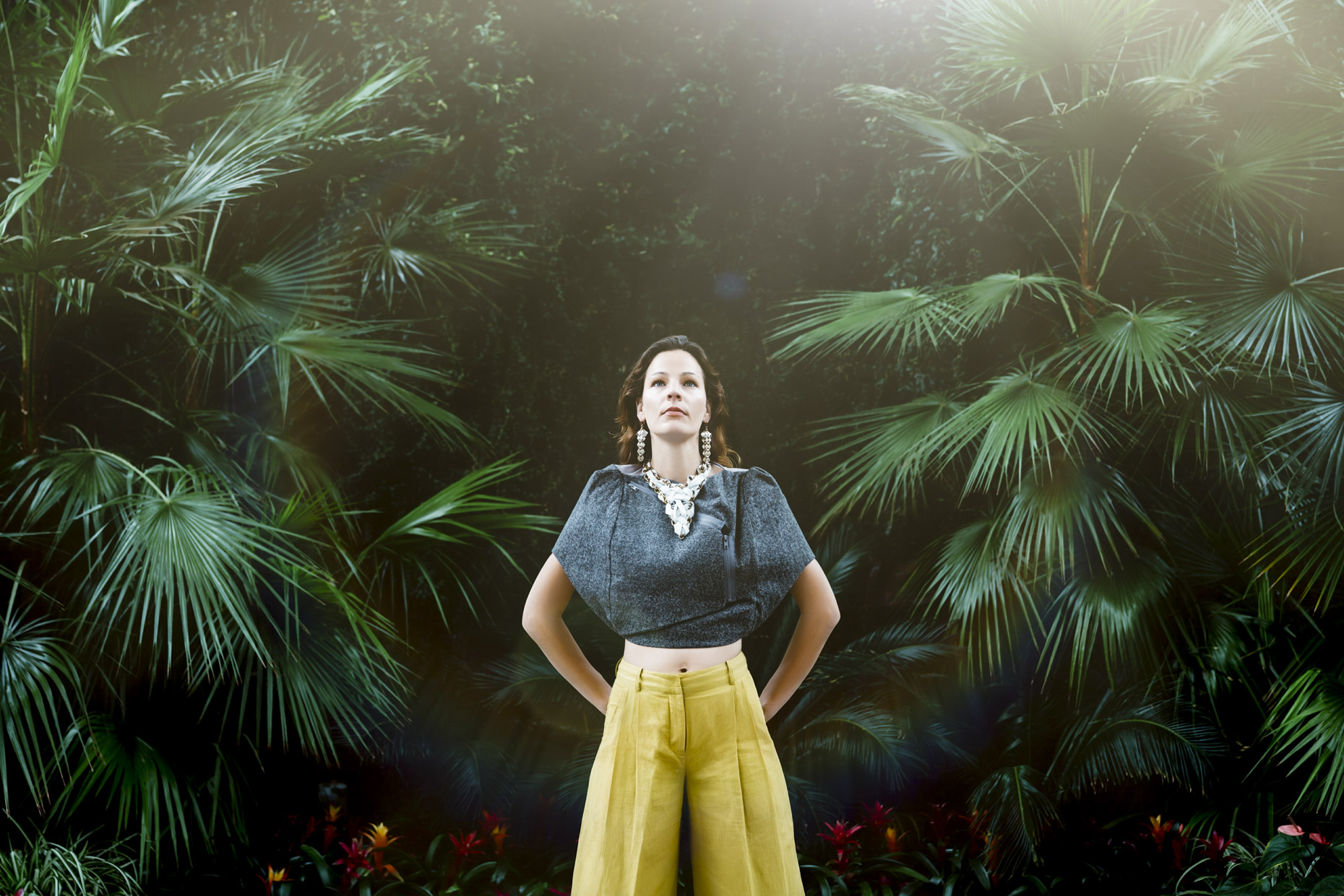 Portrait of woman in yellow pants in white leather necklace in tropical environment