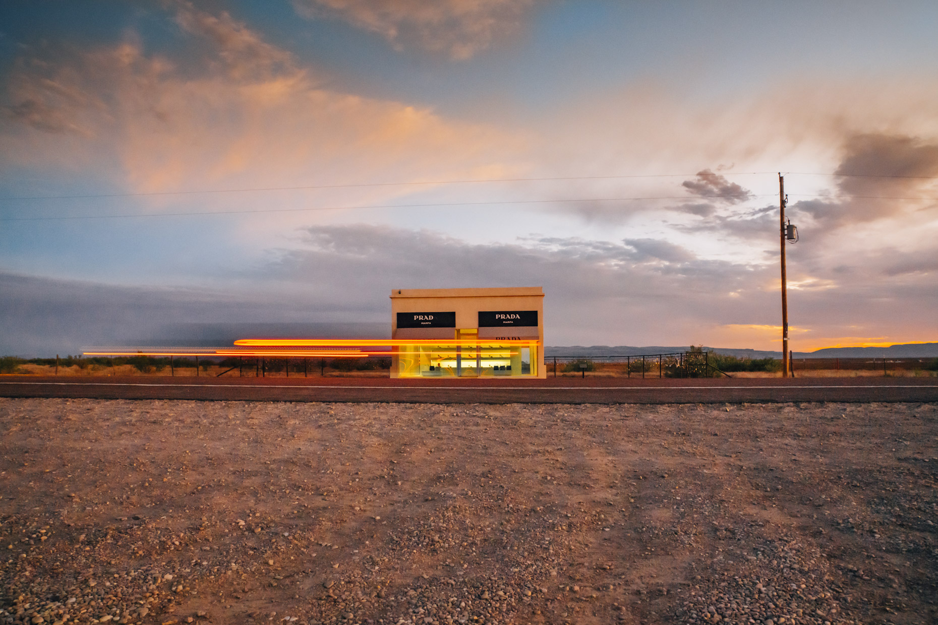 Prada store in Marfa, Texas at sunset with streak of car lights