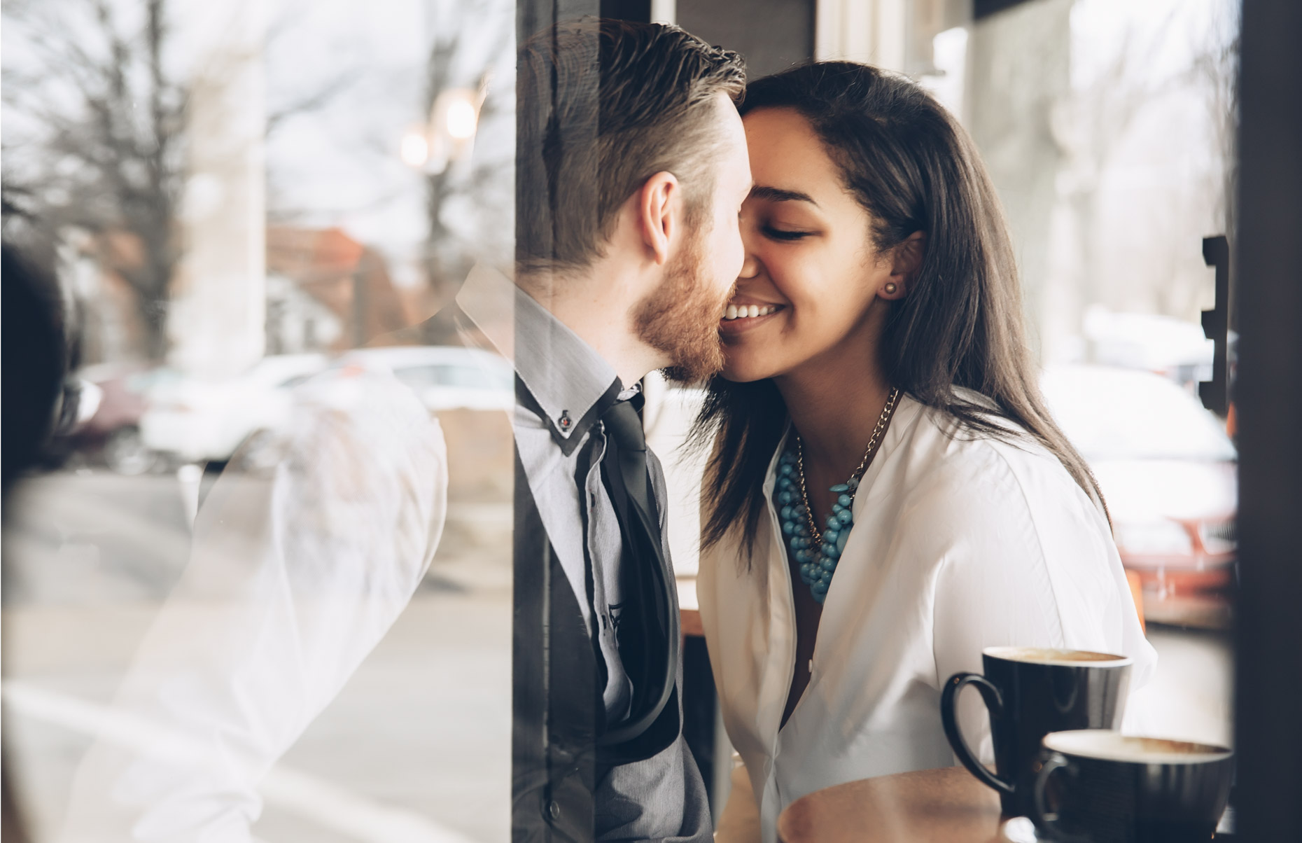 Romantic couple kissing in coffee shop window