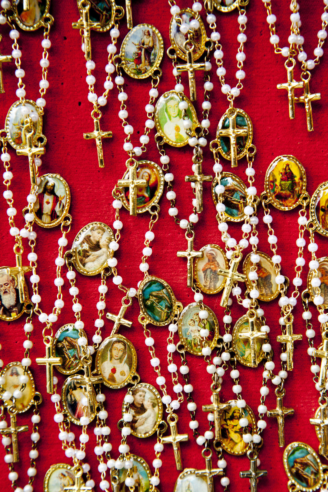 Tangle of rosaries on red cloth