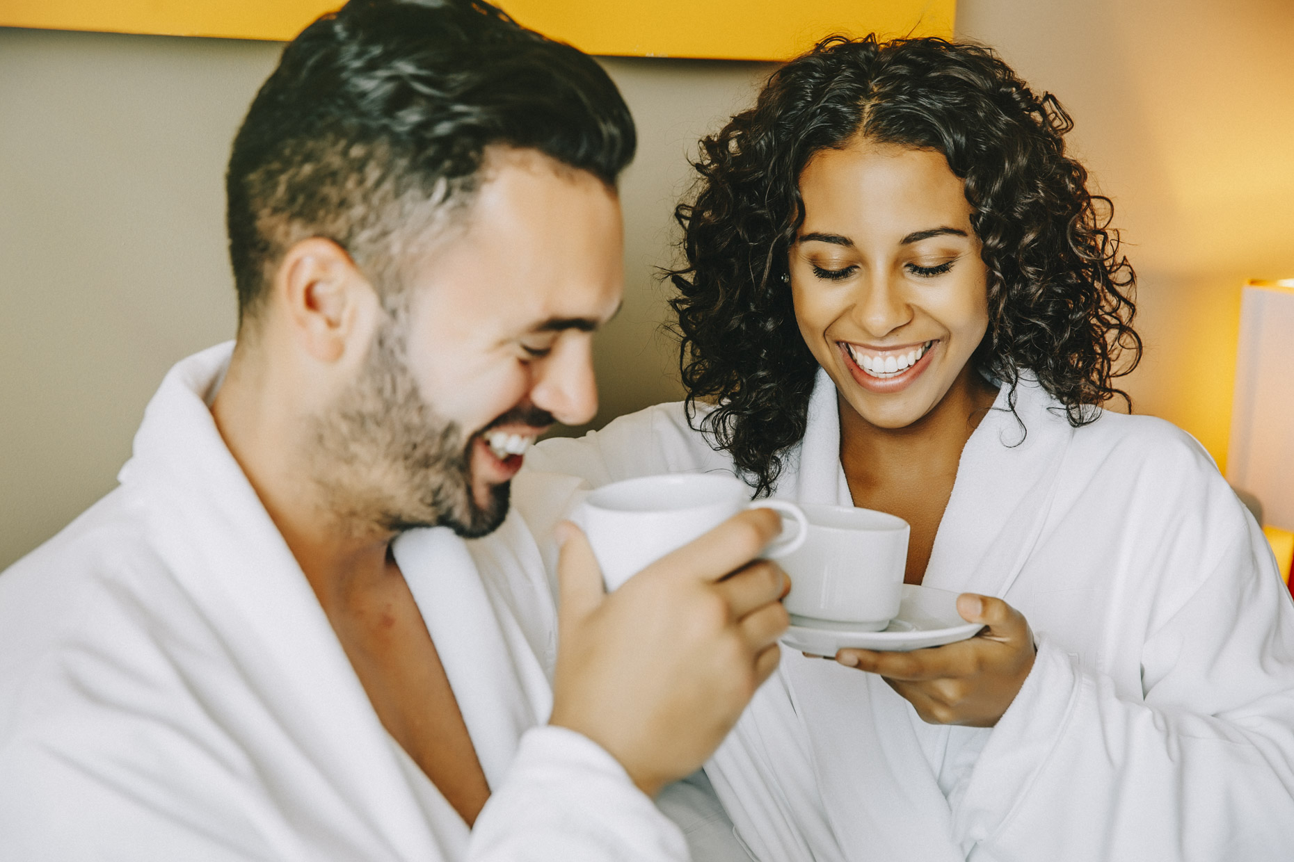 Smiling-couple-in-hotel-bed-drinking-room-service-coffee-Inti_St-Clair-is201504251482