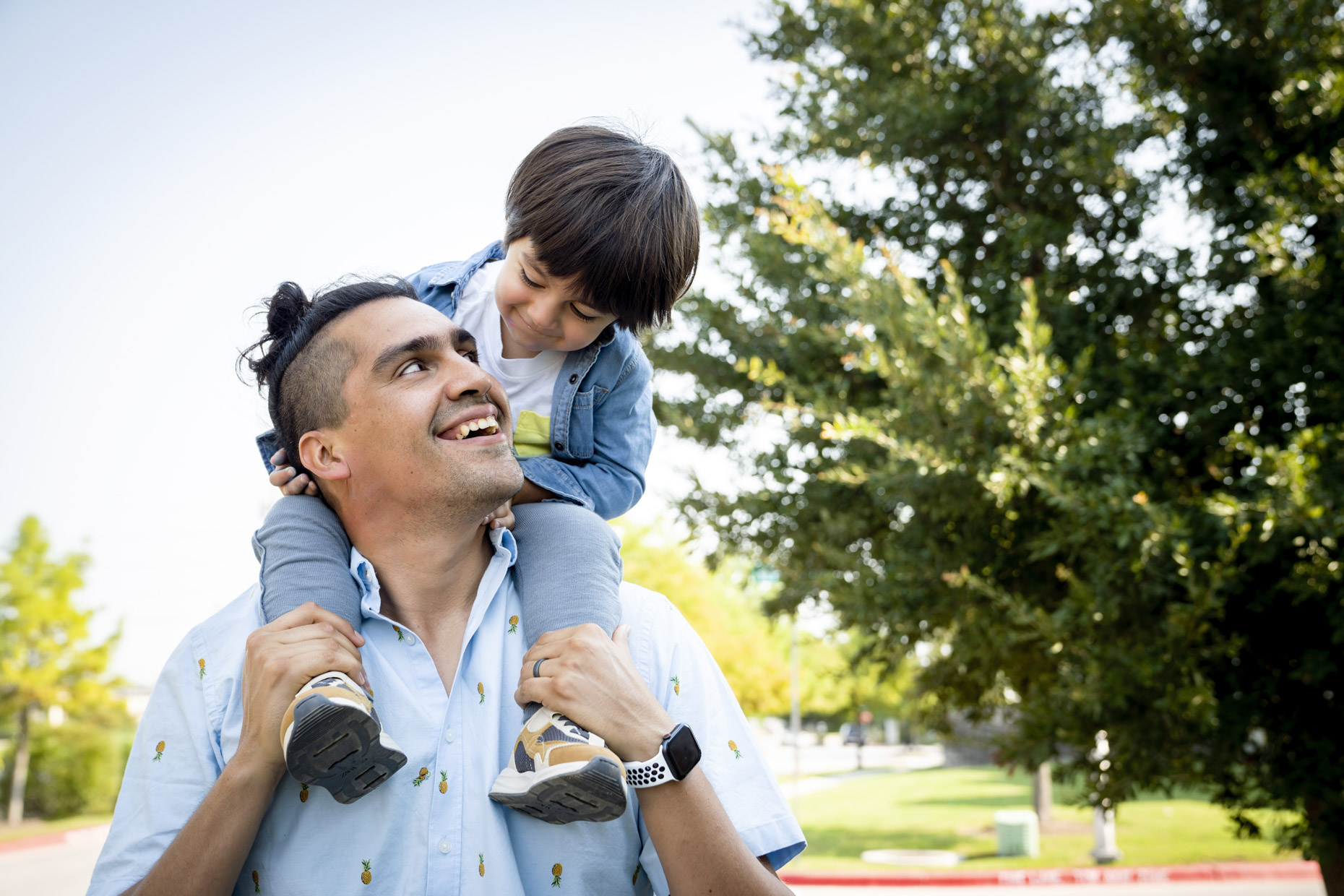 Smiling dad carrying son on shoulders