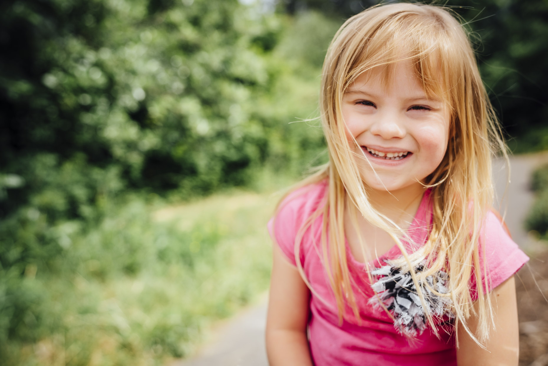 Smiling blonde girl with down syndrome playing outside