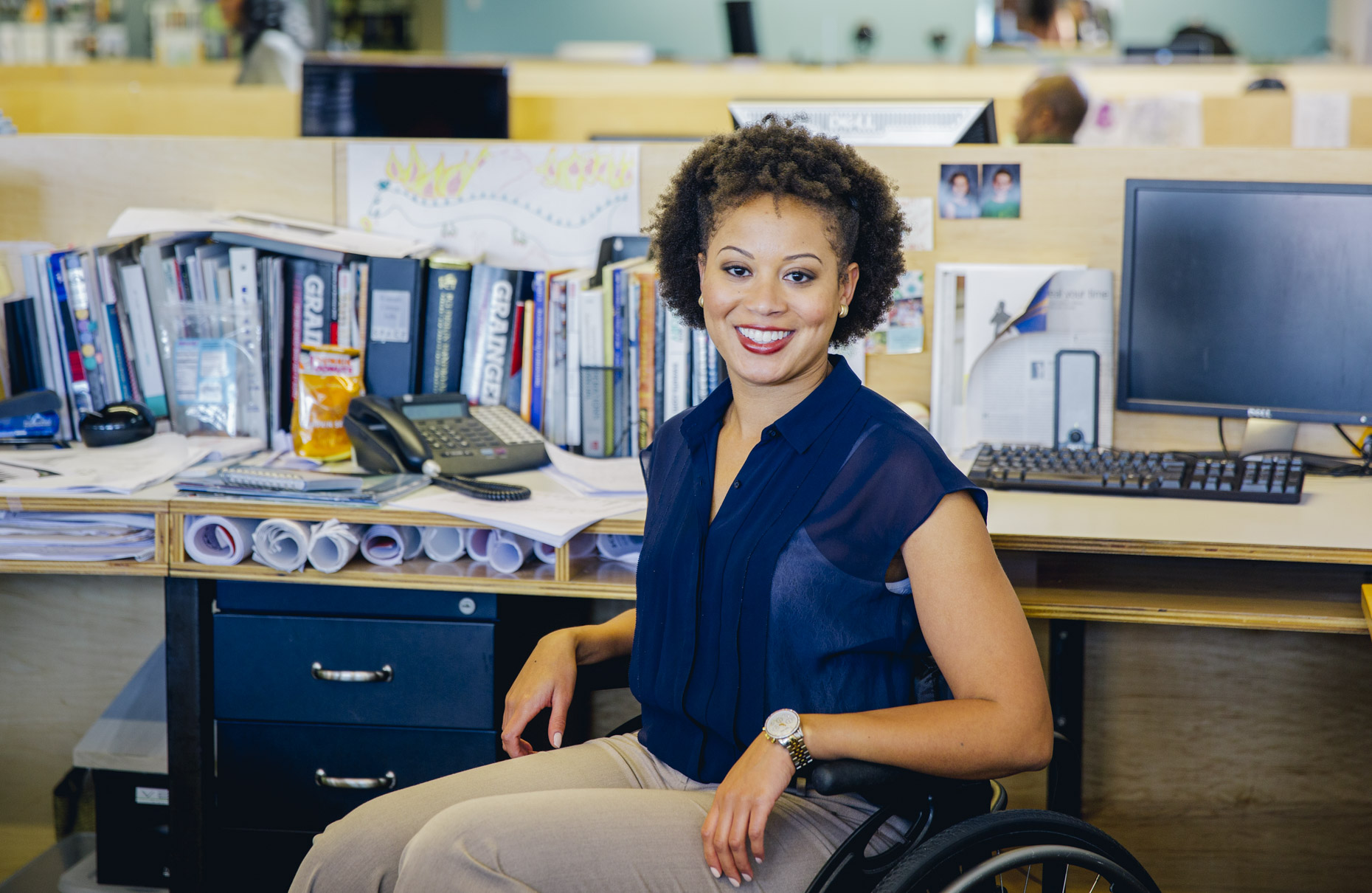 Smiling handicapped woman in wheelchair in office
