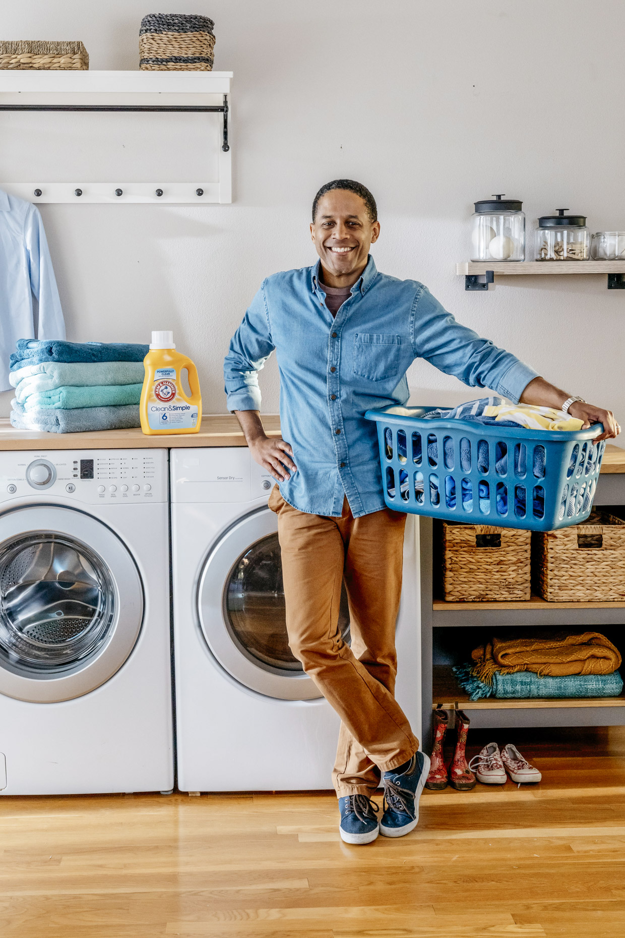 Smiling man with bottle of Arm and Hammer detergent and basket of laundry