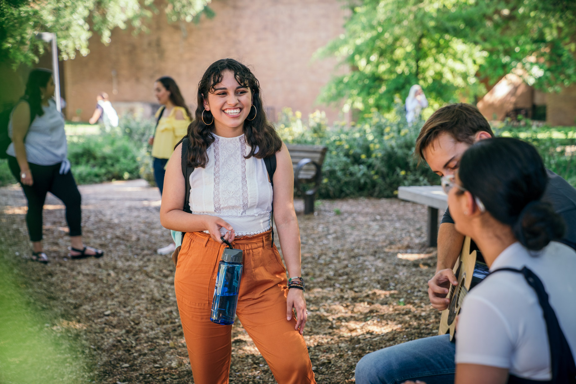 Smiling woman talking with friends on college campus