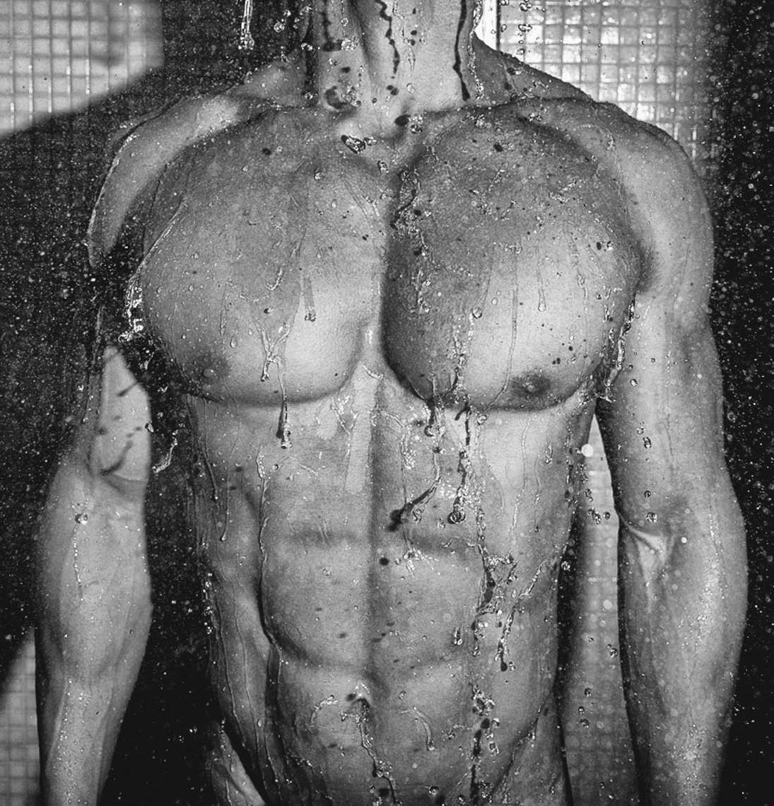 Torso of fit male body in shower 