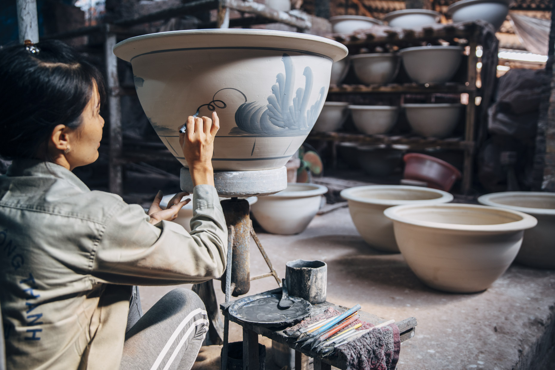 Woman hand painting clay pot in Vietnam