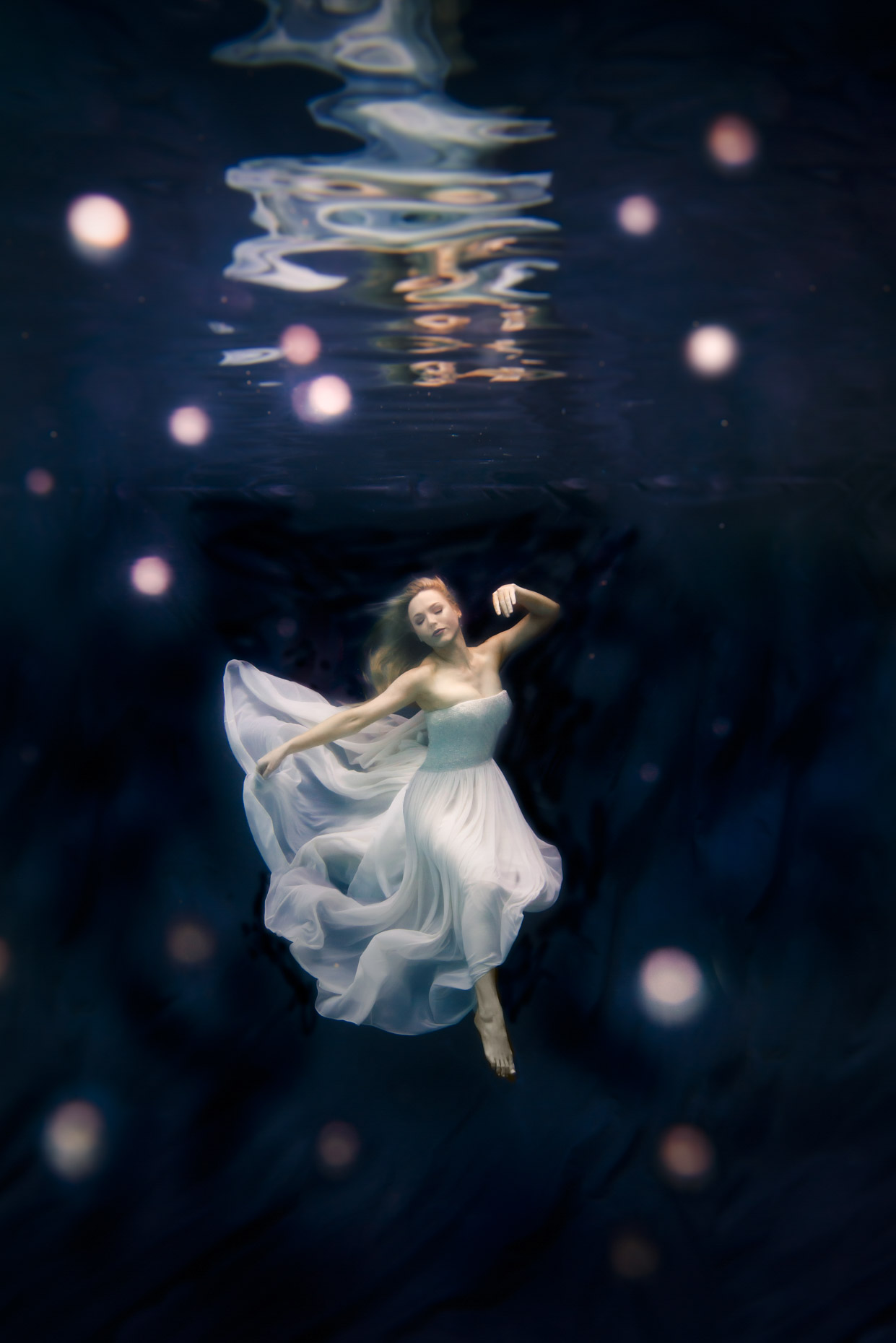 Woman in white dress under water