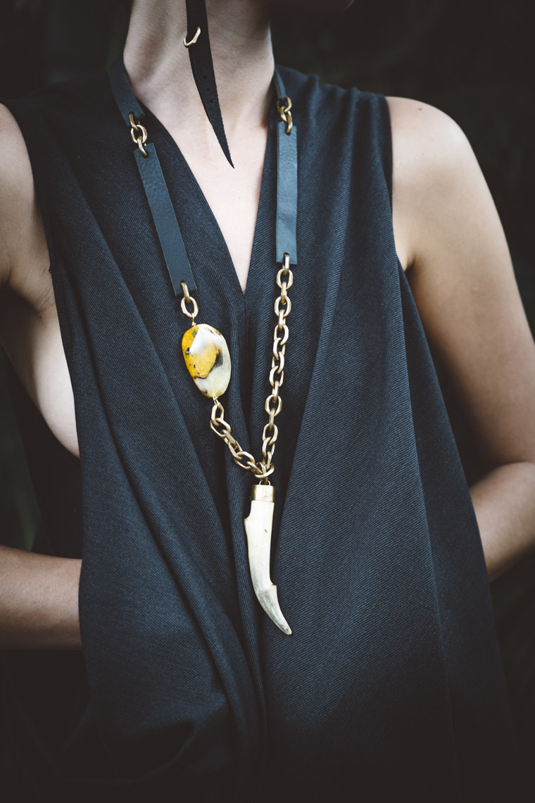 Woman wearing black leather brass bone and stone necklace