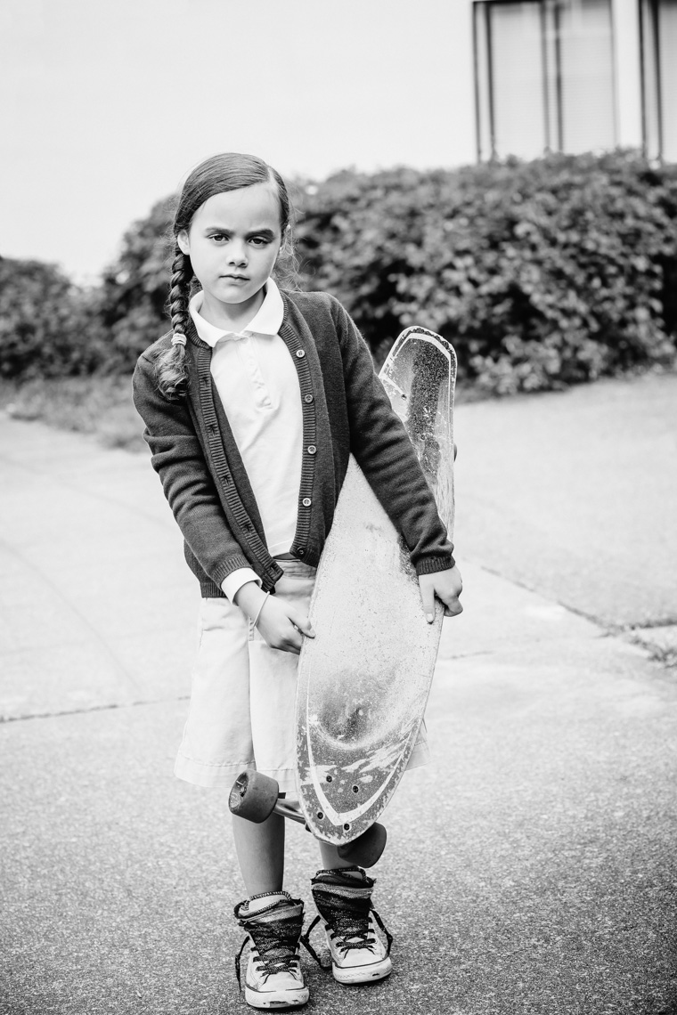 Girl in school uniform holding skateboard